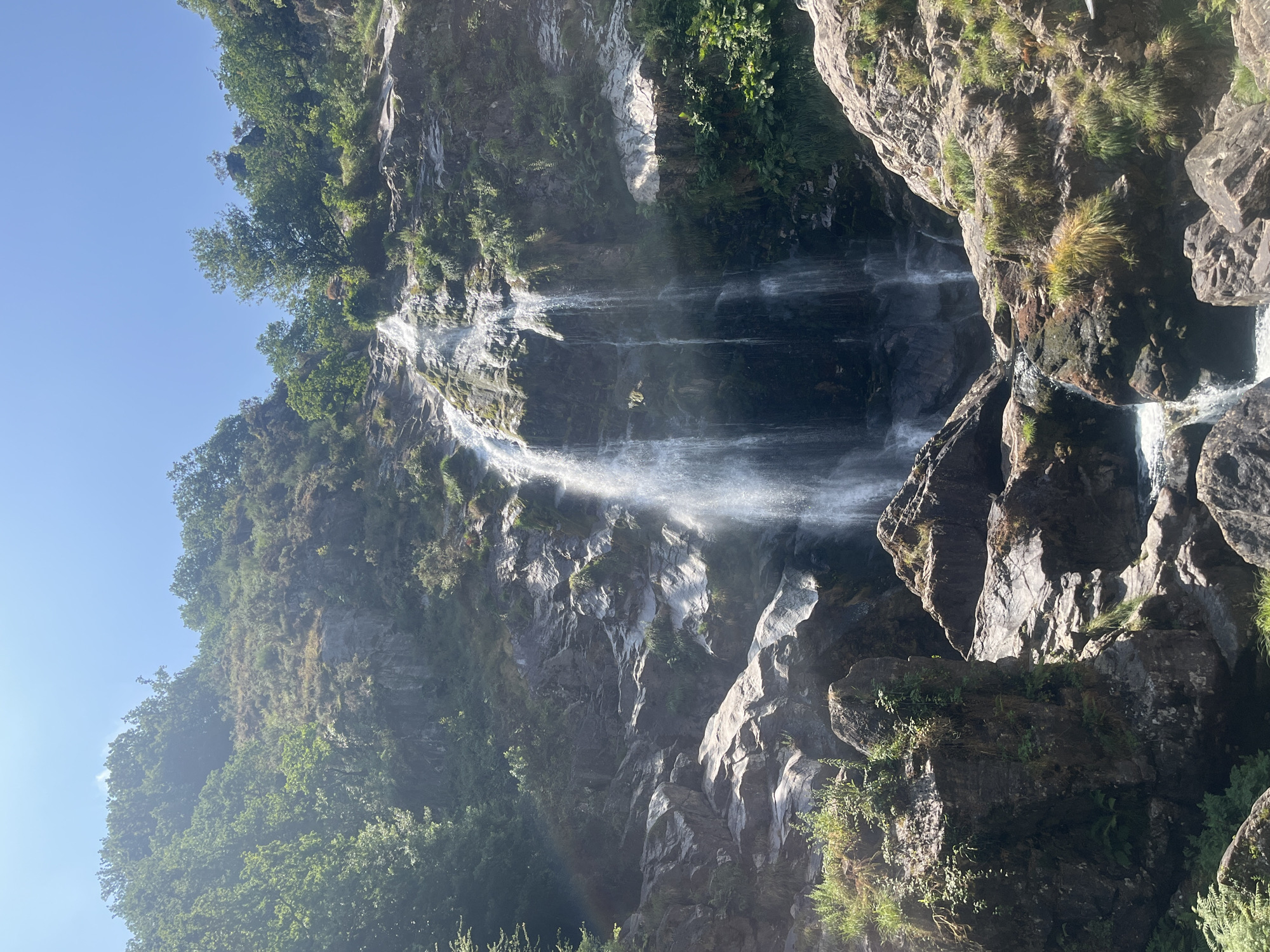 Waterfall splits into streams down a mossy cliff in Galicia