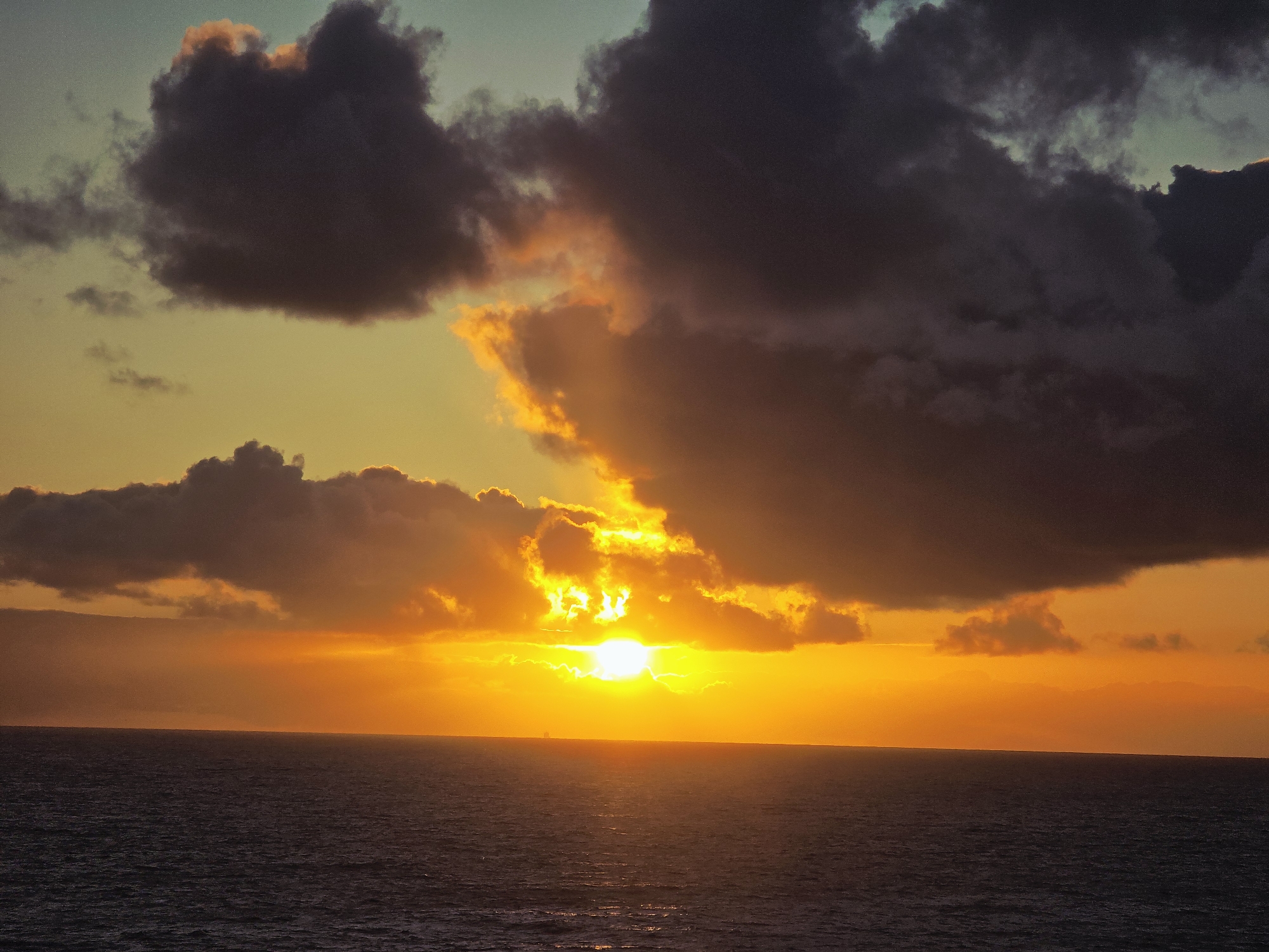 Dramatic sunset illuminates cloudy sky over Norwegian waters