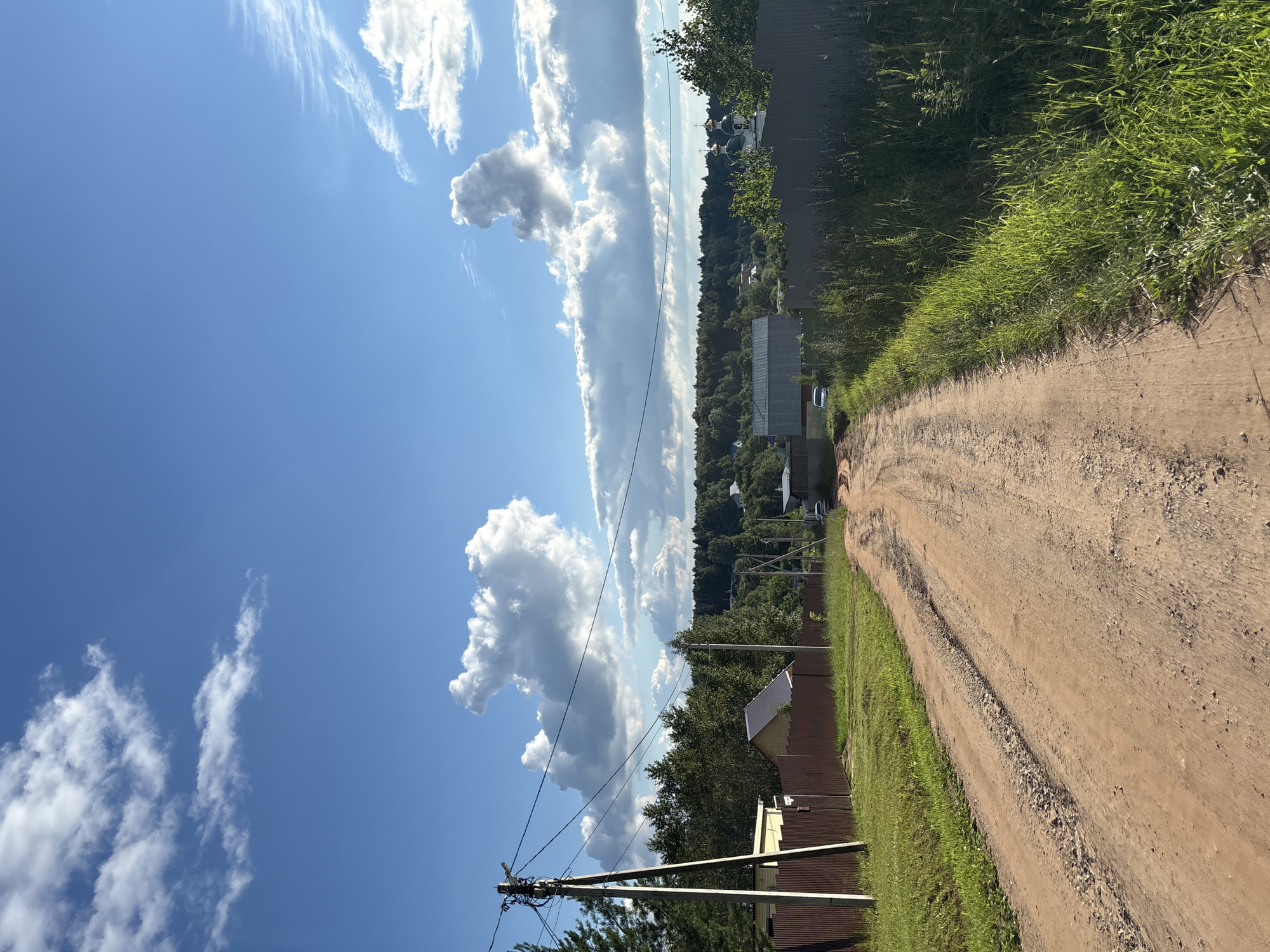 Orange tanker trucks parked in a rural Russian field on a summer day