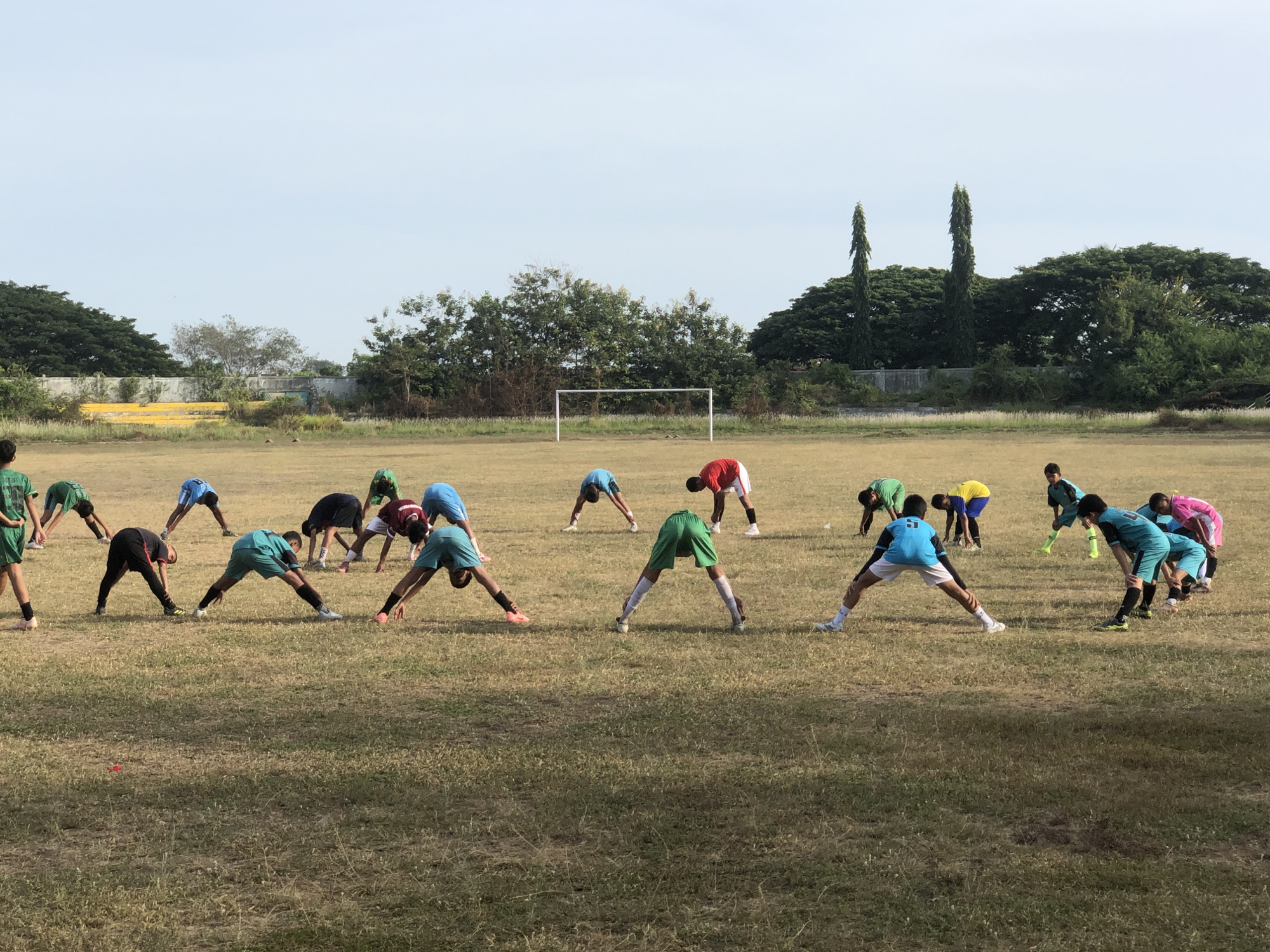 Sports drills and street traffic near a Lhokseumawe stadium