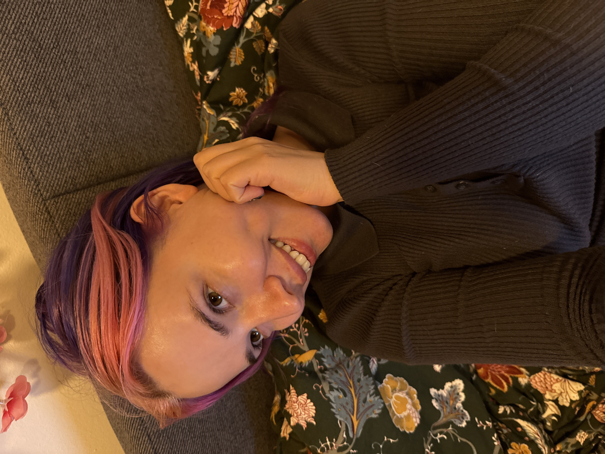 Woman with colorful hair relaxes on couch in Zagreb