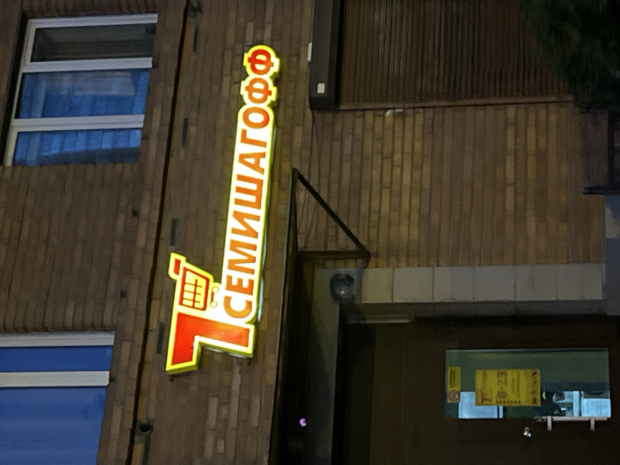 Dusk falls on a Ladozhskoe Ozero street, neon sign glowing