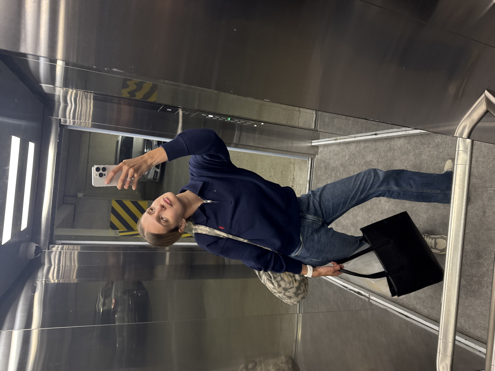 Woman takes elevator selfies in stainless steel cabin