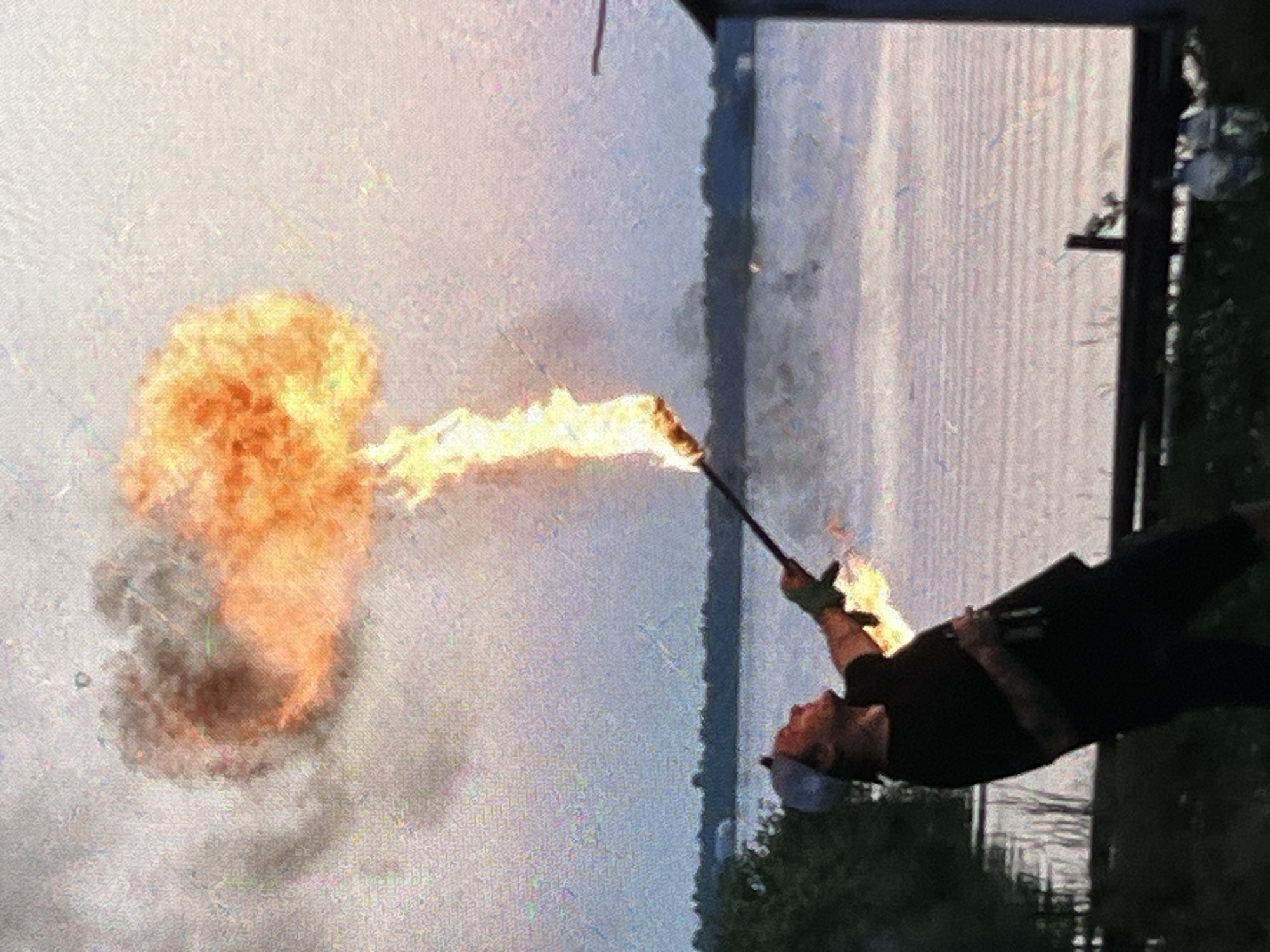 Fire performance with torch and staff at dusk in Tyumen