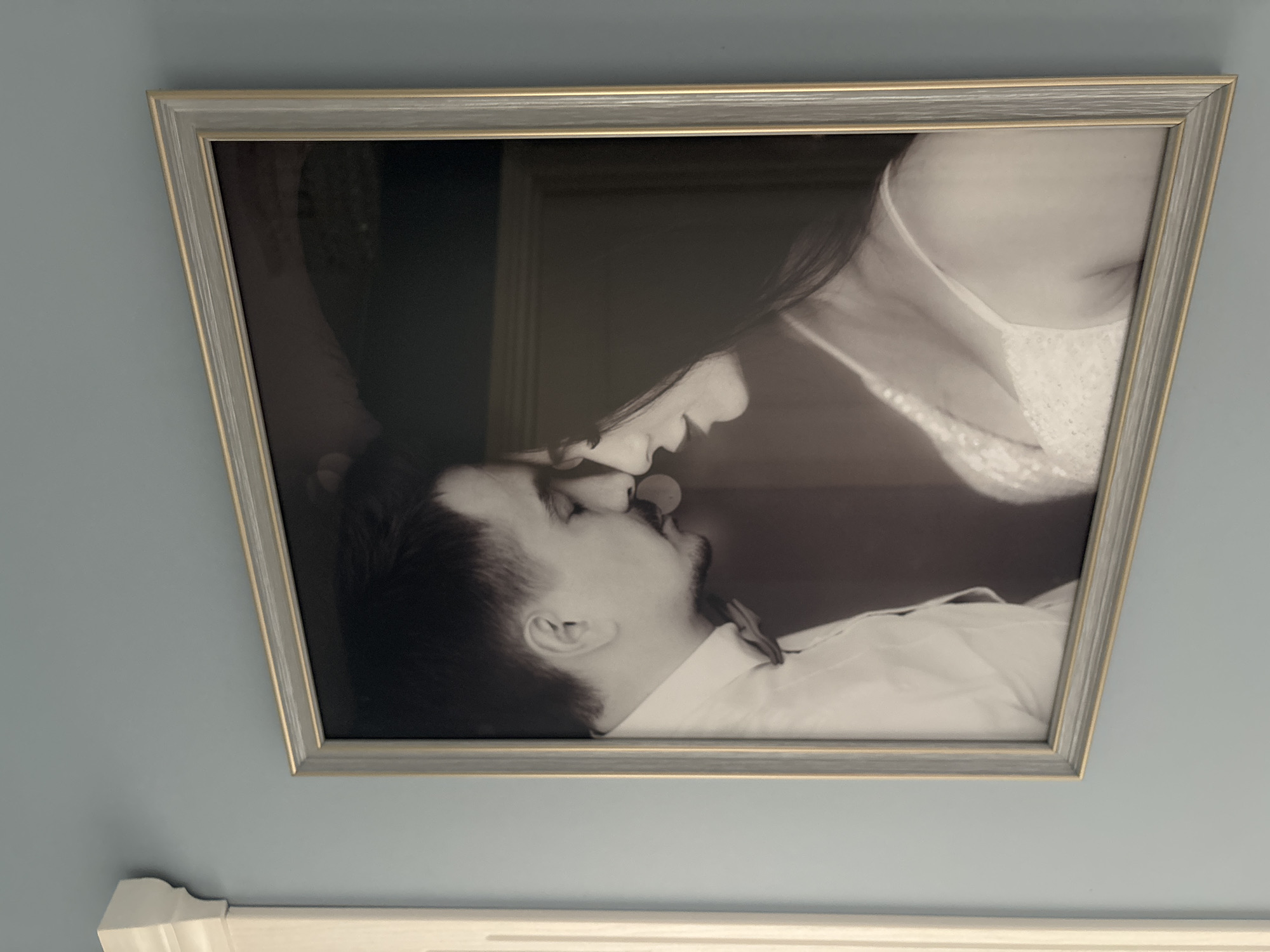 Vintage couple's photograph observed on blue wall