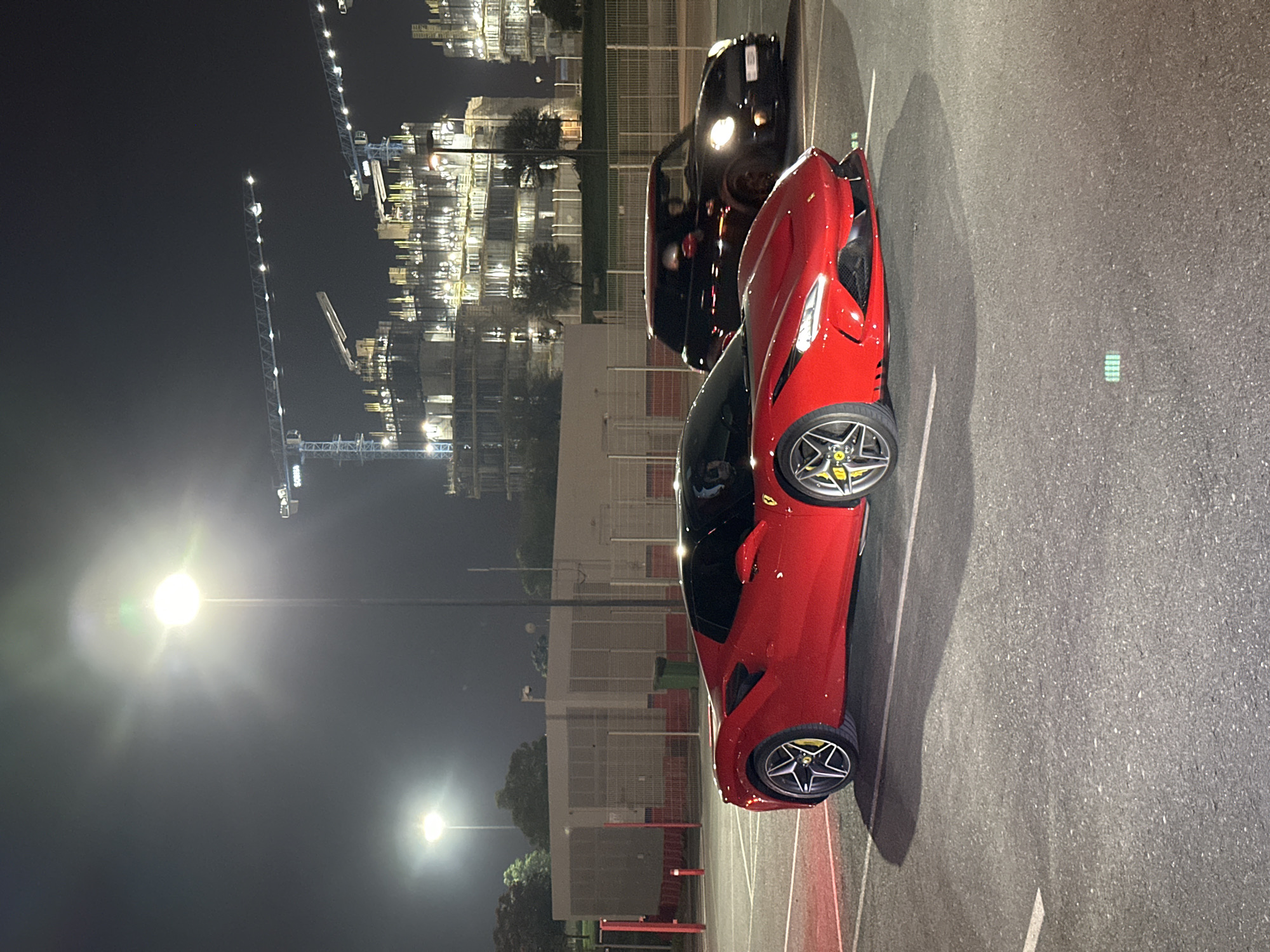 Nighttime car event at Dubai Autodrome with racing and sports cars