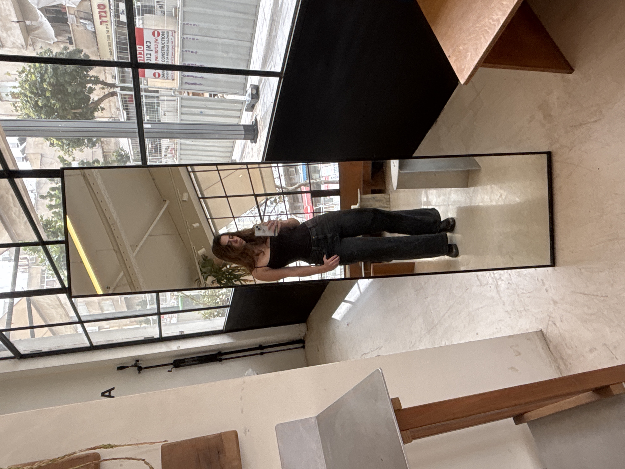 Person takes mirror selfie in Tel Aviv indoor location