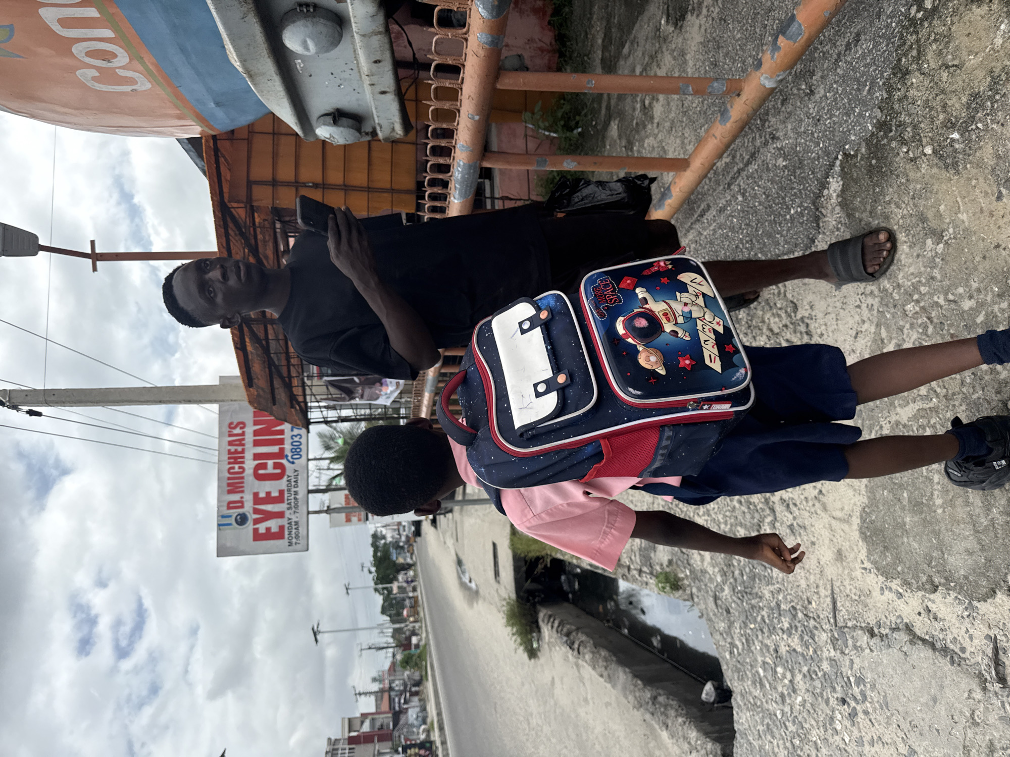 Afternoon street life in Ado, Nigeria — students and passersby