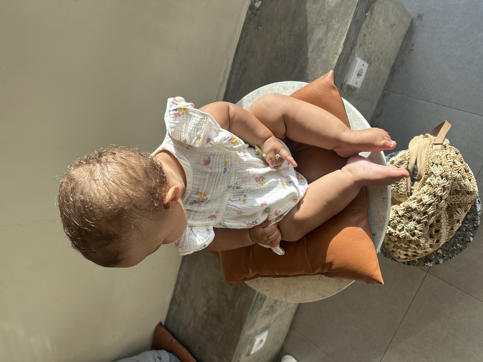 Baby in floral dress photographed with flowers in North Kuta