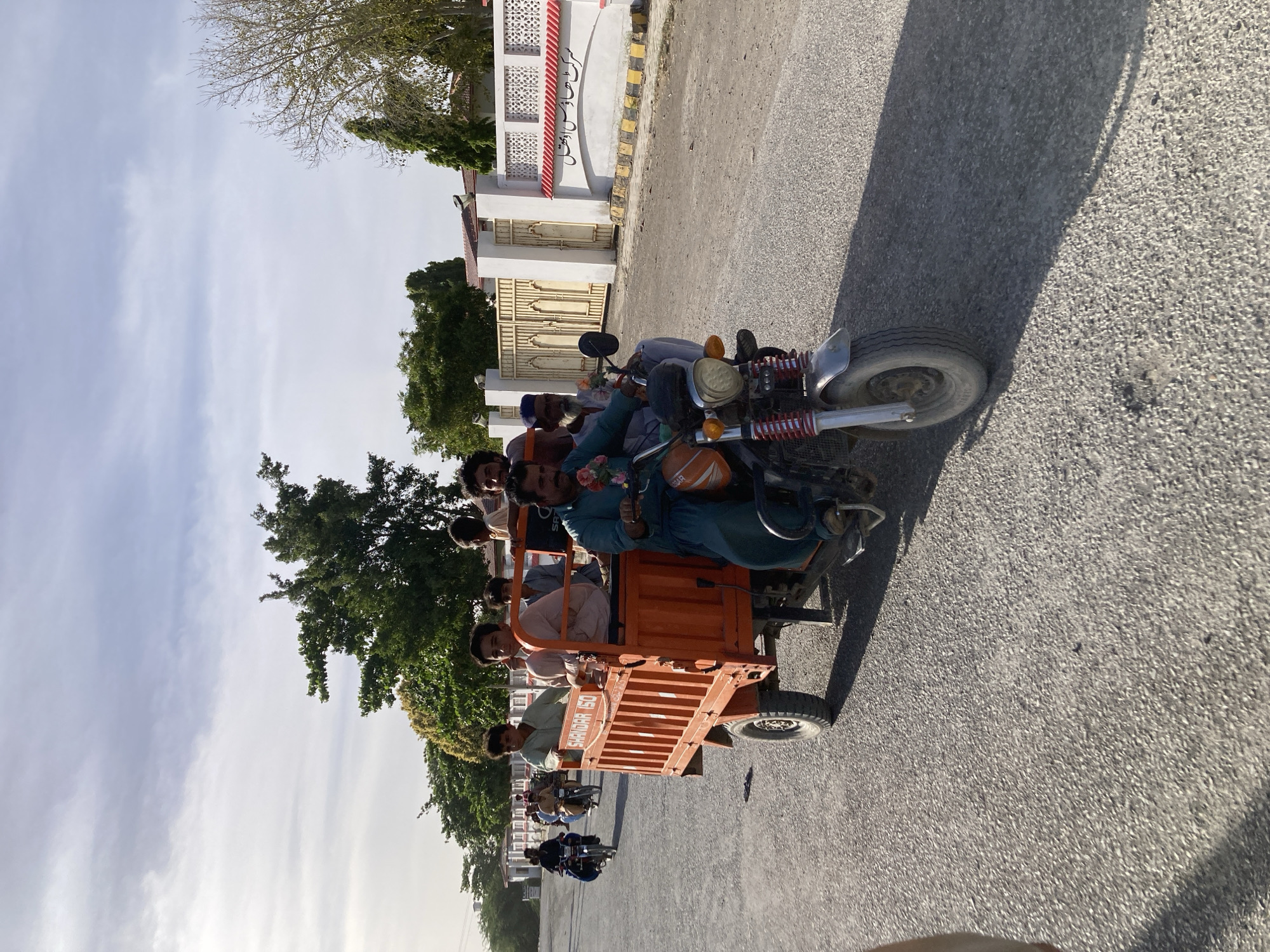 Orange rickshaw spotted on Uthal street under cloudy skies