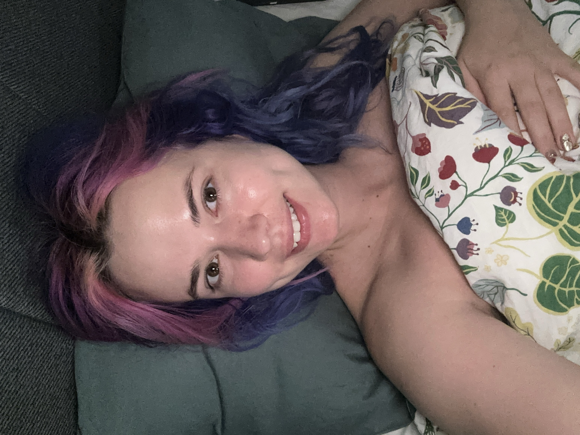 Woman with colorful hair relaxes on couch in Zagreb
