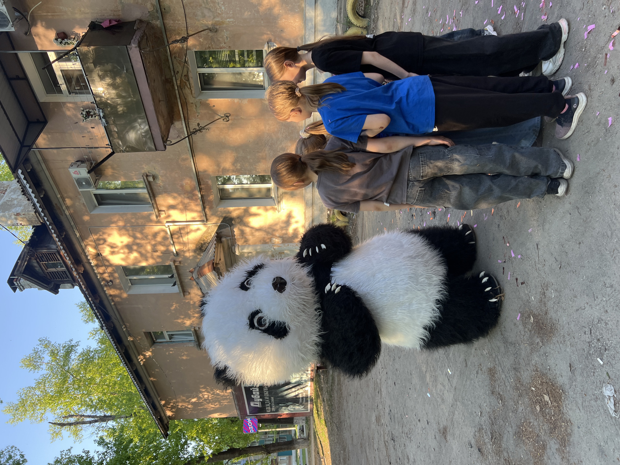 Panda mascot entertains children in outdoor gathering