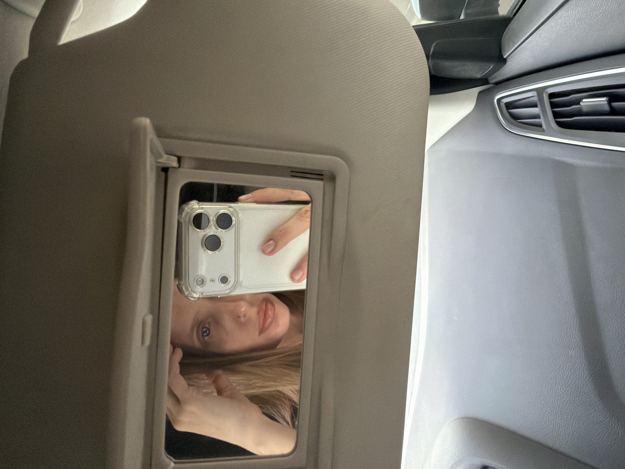 Person takes selfie in car sun visor mirror