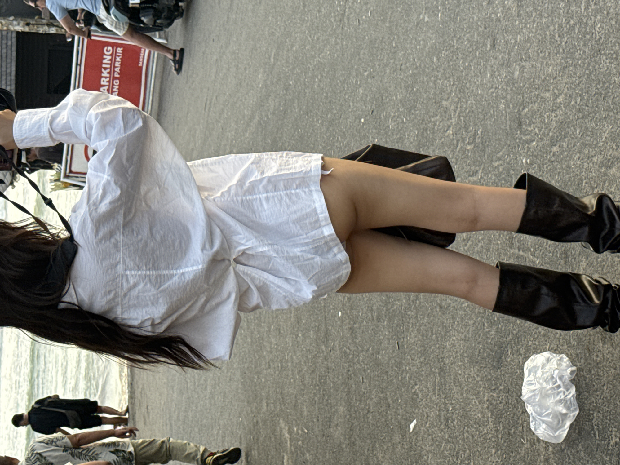 Woman in white outfit observed near shoreline in North Kuta