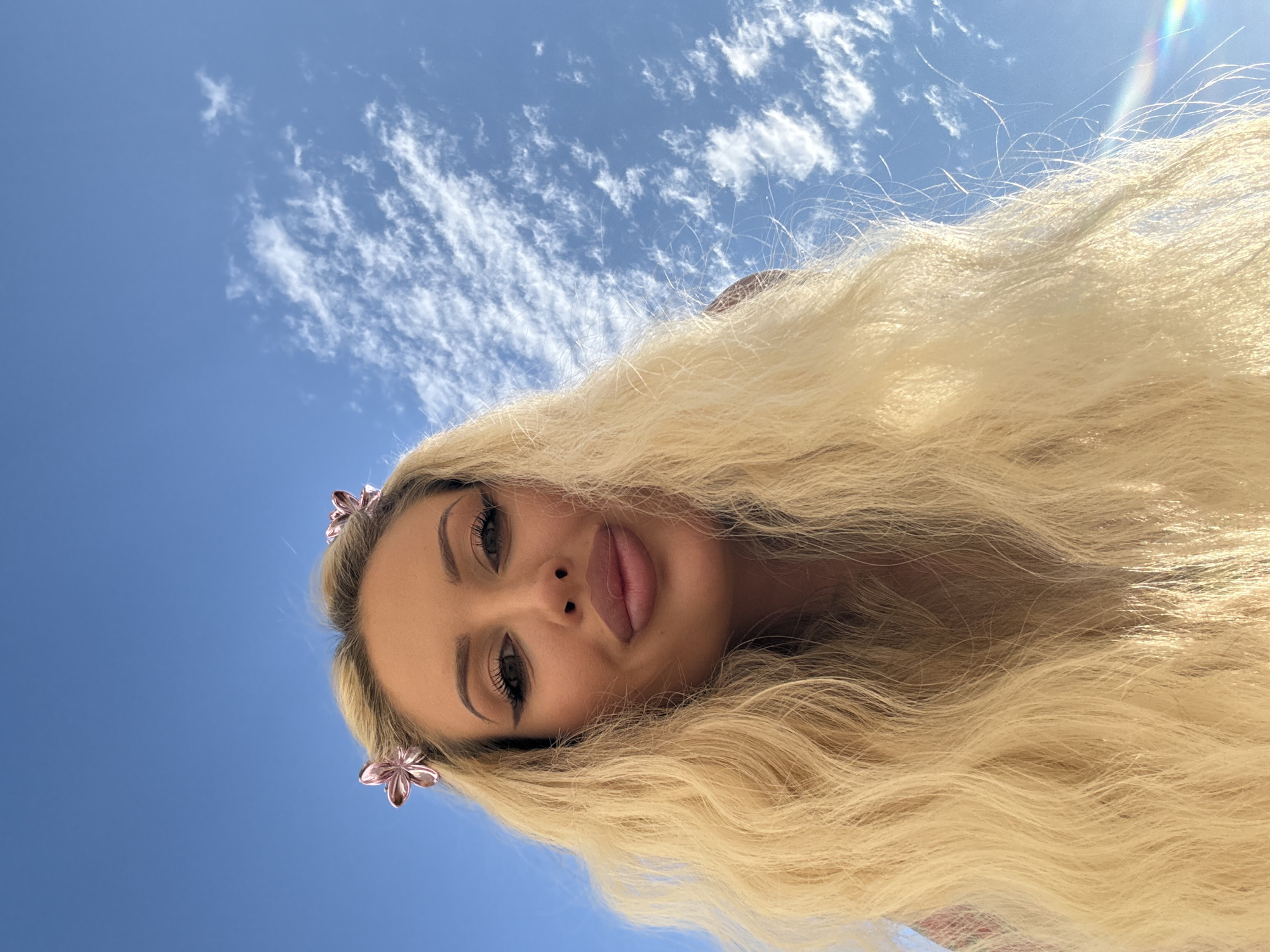 Low-angle portrait against a bright blue sky