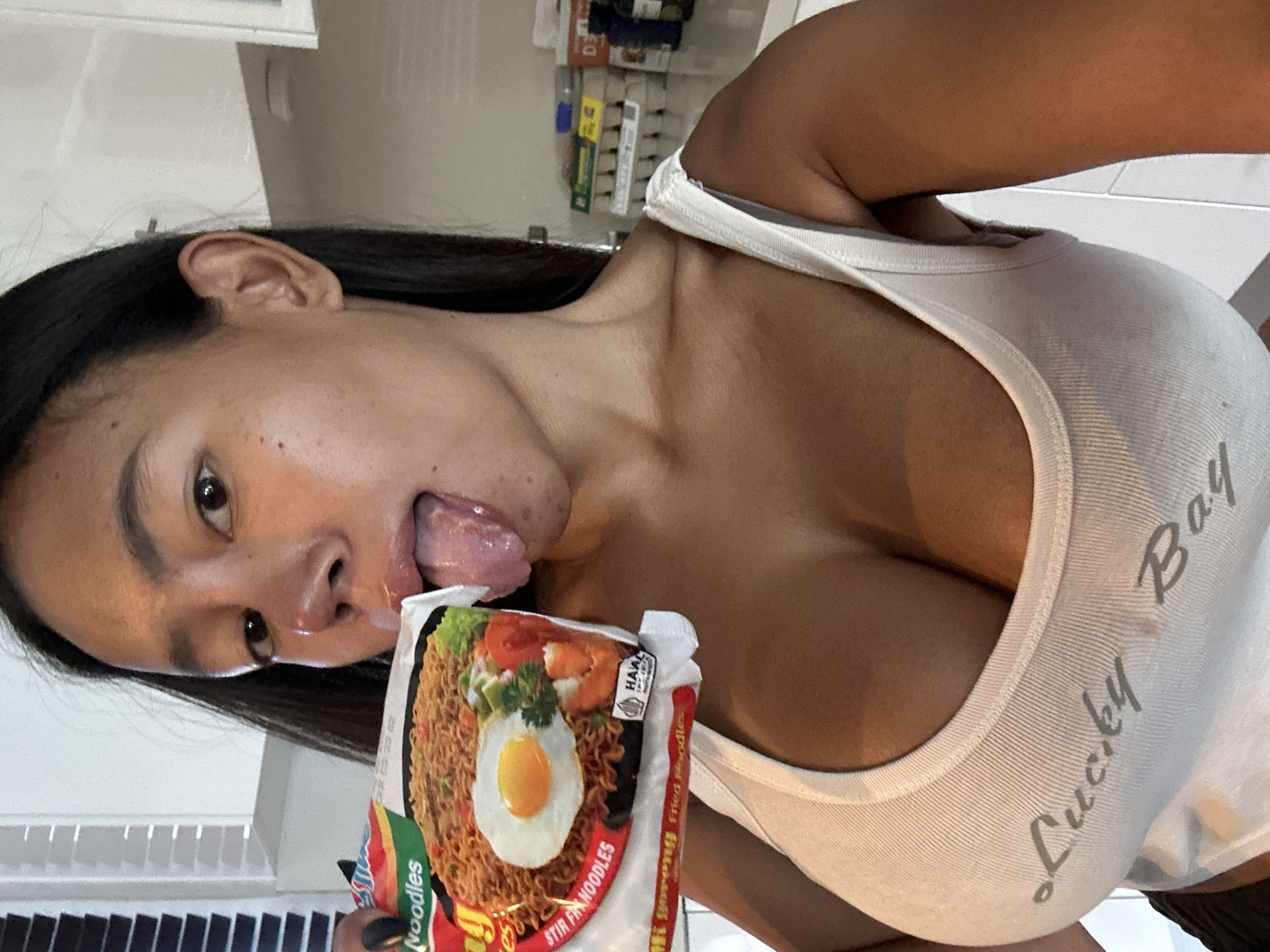 Woman poses playfully with instant noodles in Maroubra kitchen