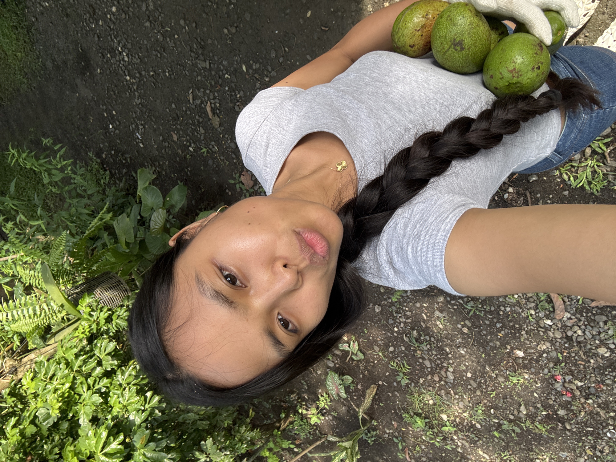 Woman holds avocados outdoors in Carmen, Philippines