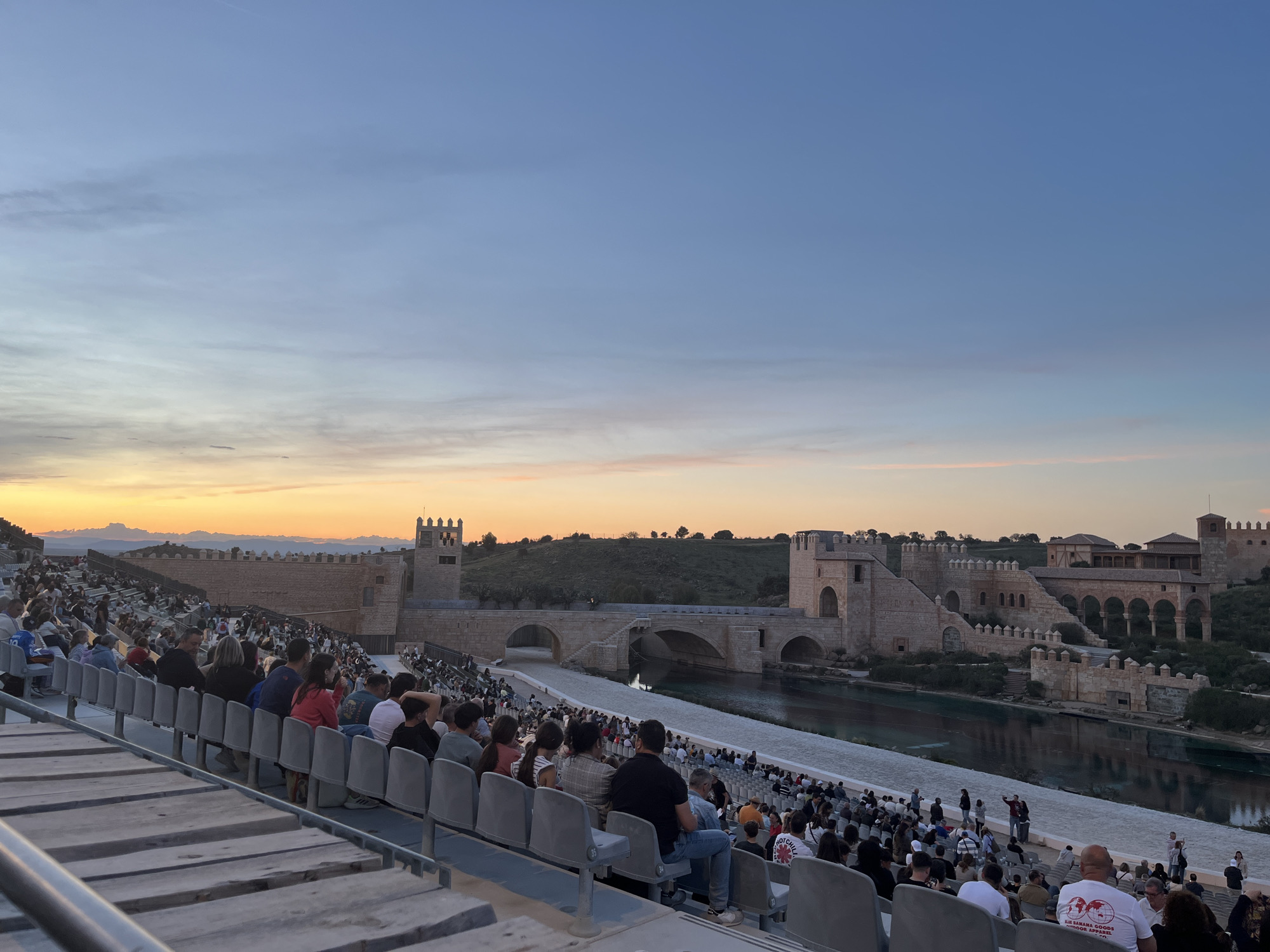 Outdoor audience gathers at castle venue for evening performance