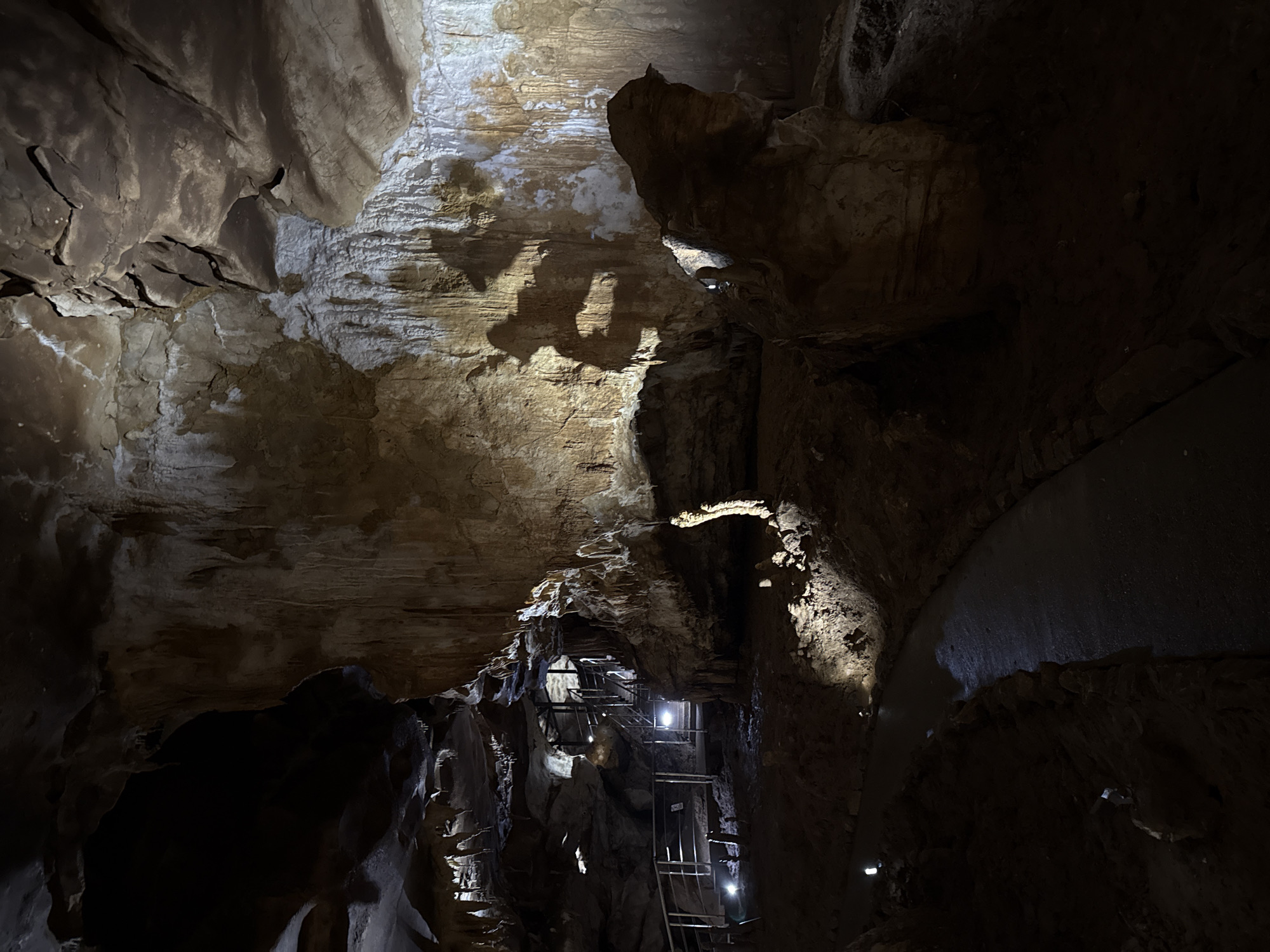 Tourist documents walkthrough of illuminated Prometheus Cave in Georgia