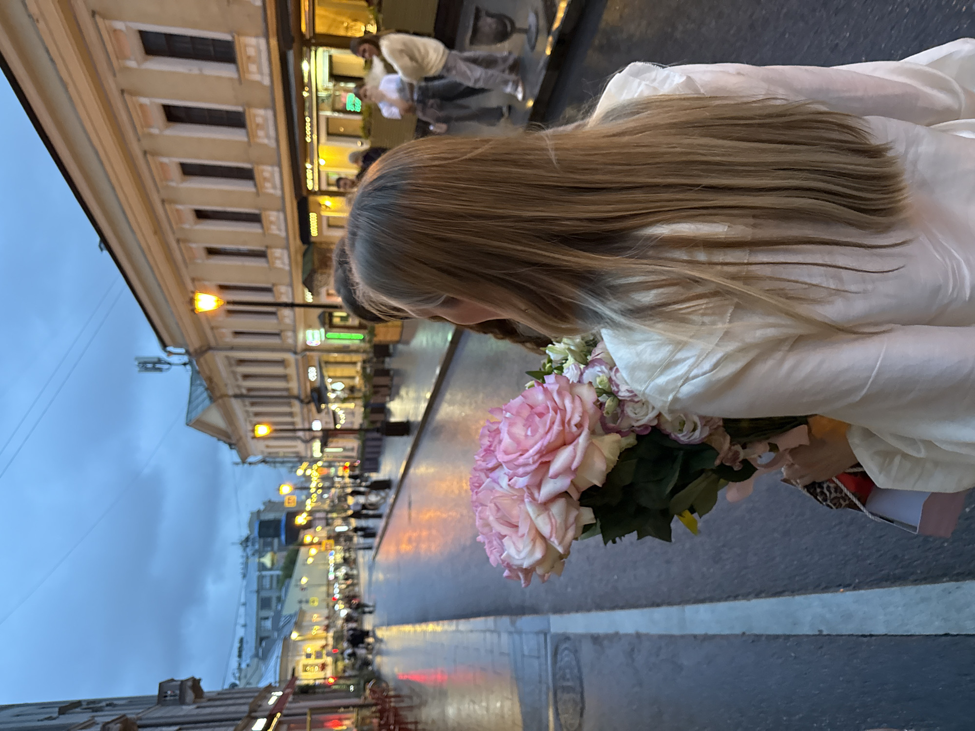 Pale pink roses on a rain-slicked Moscow evening street