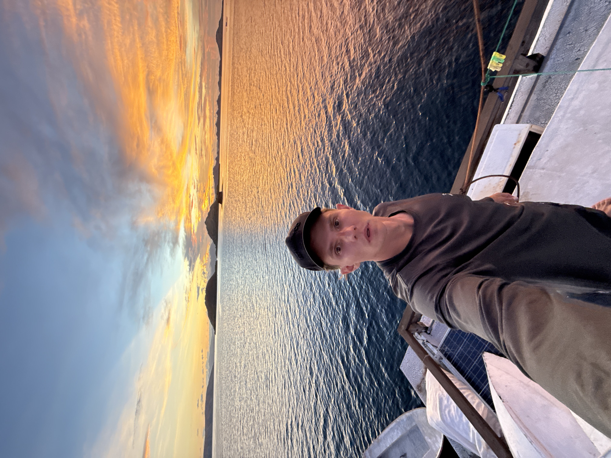 Man photographed on boat deck during Indonesian sunset
