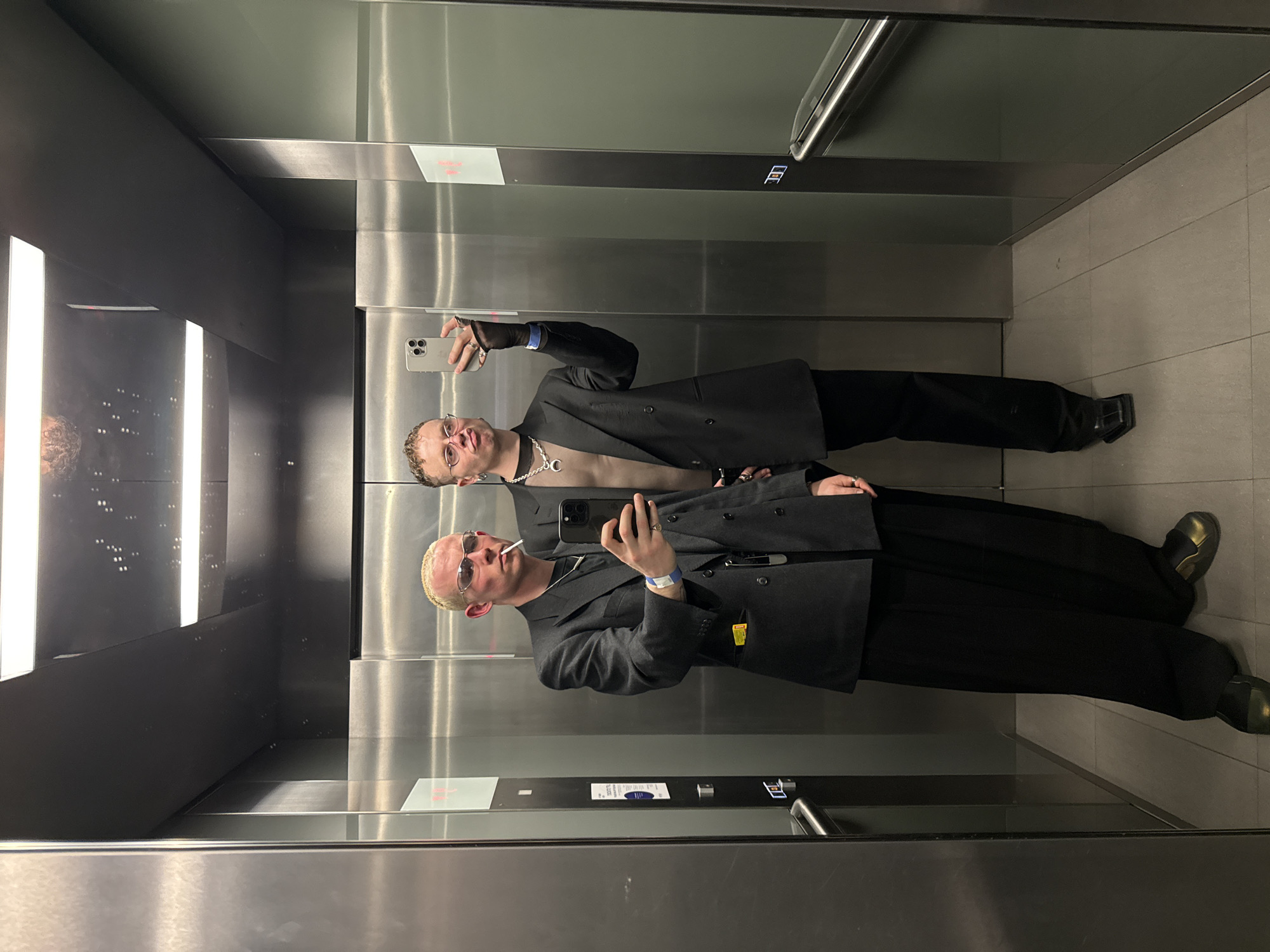 Two people take mirror selfie in London elevator