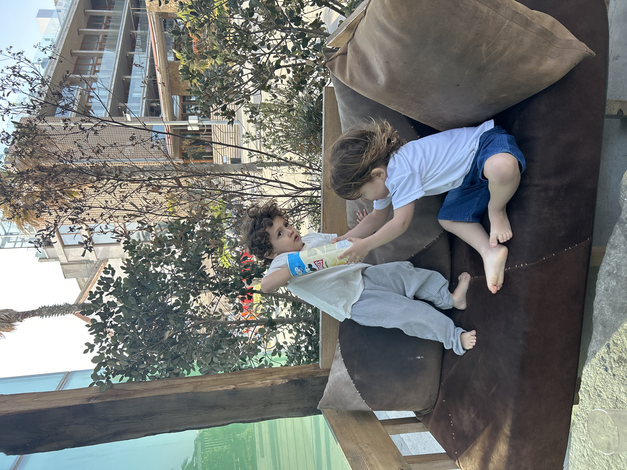 Children play outdoors on Barcelona terrace during sunny afternoon