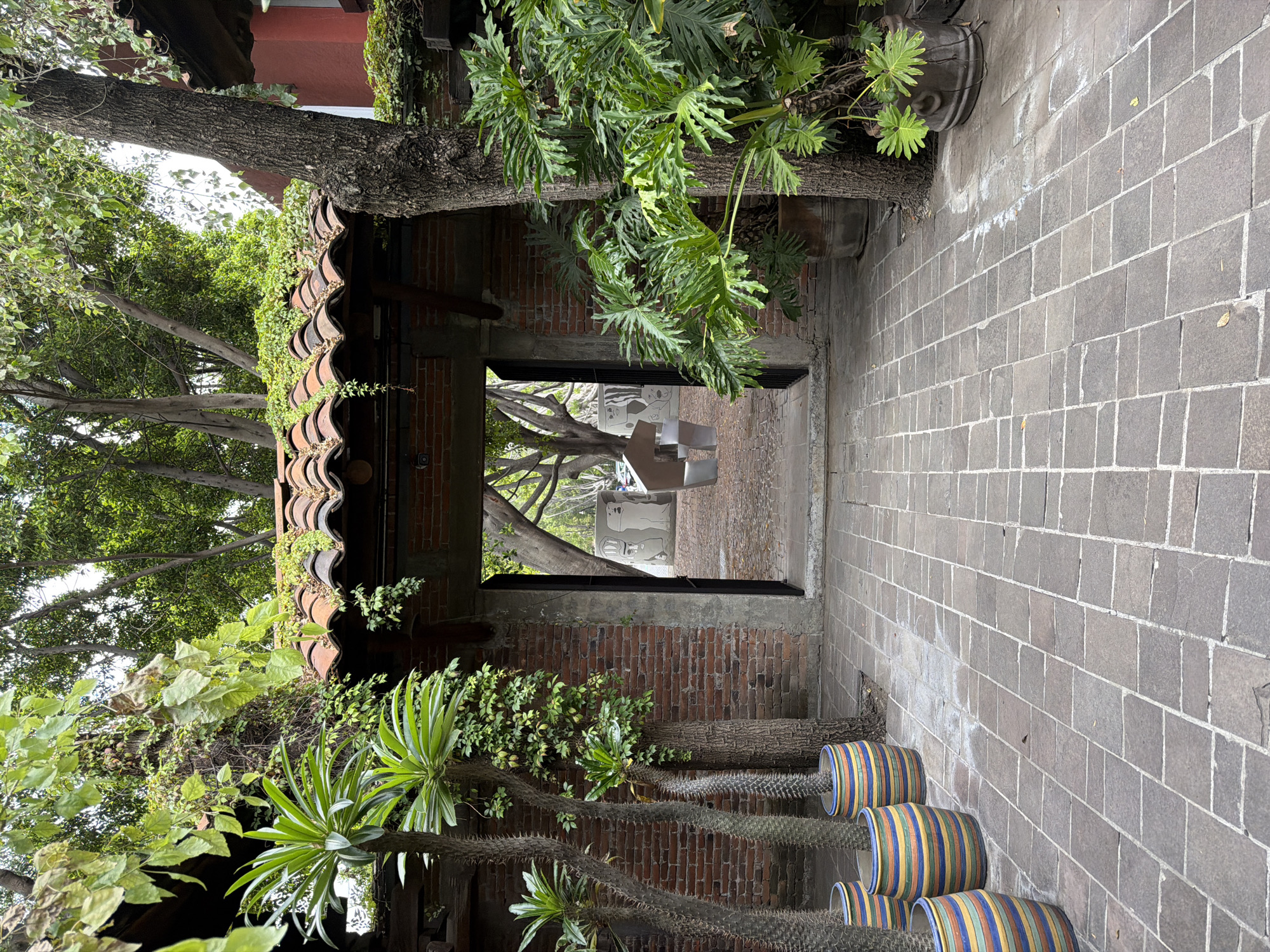 Vegetation-covered brick archway frames artistic alleyway in Puebla