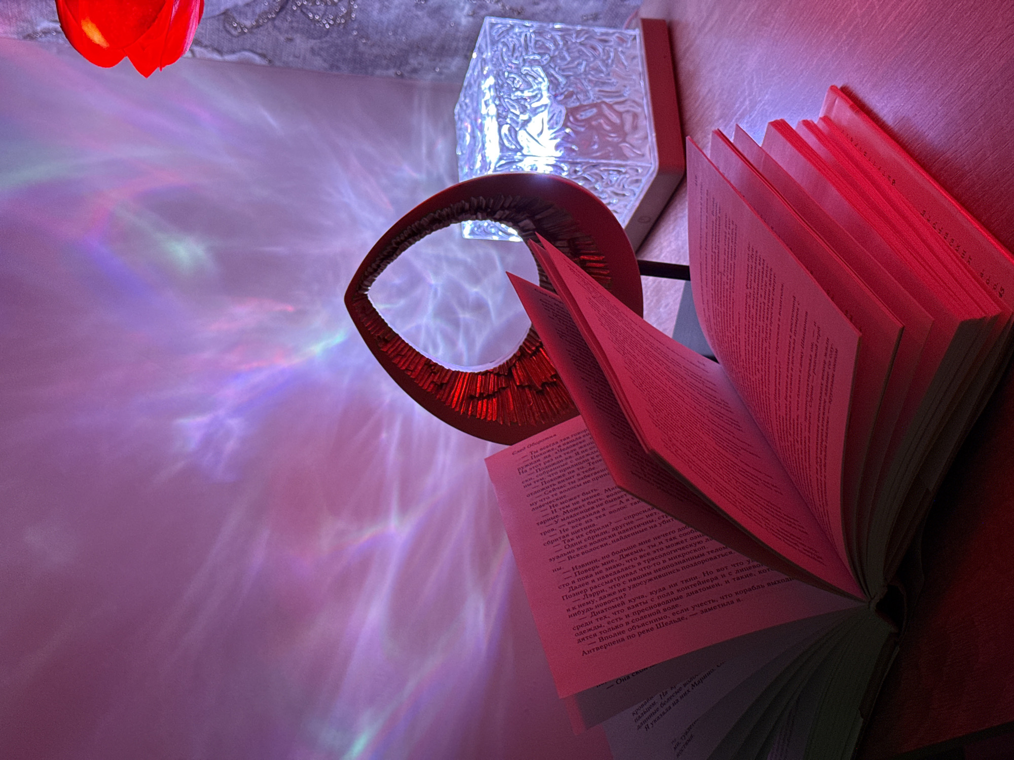 Indoor scene documented with colorful lighting, books, moon lamp