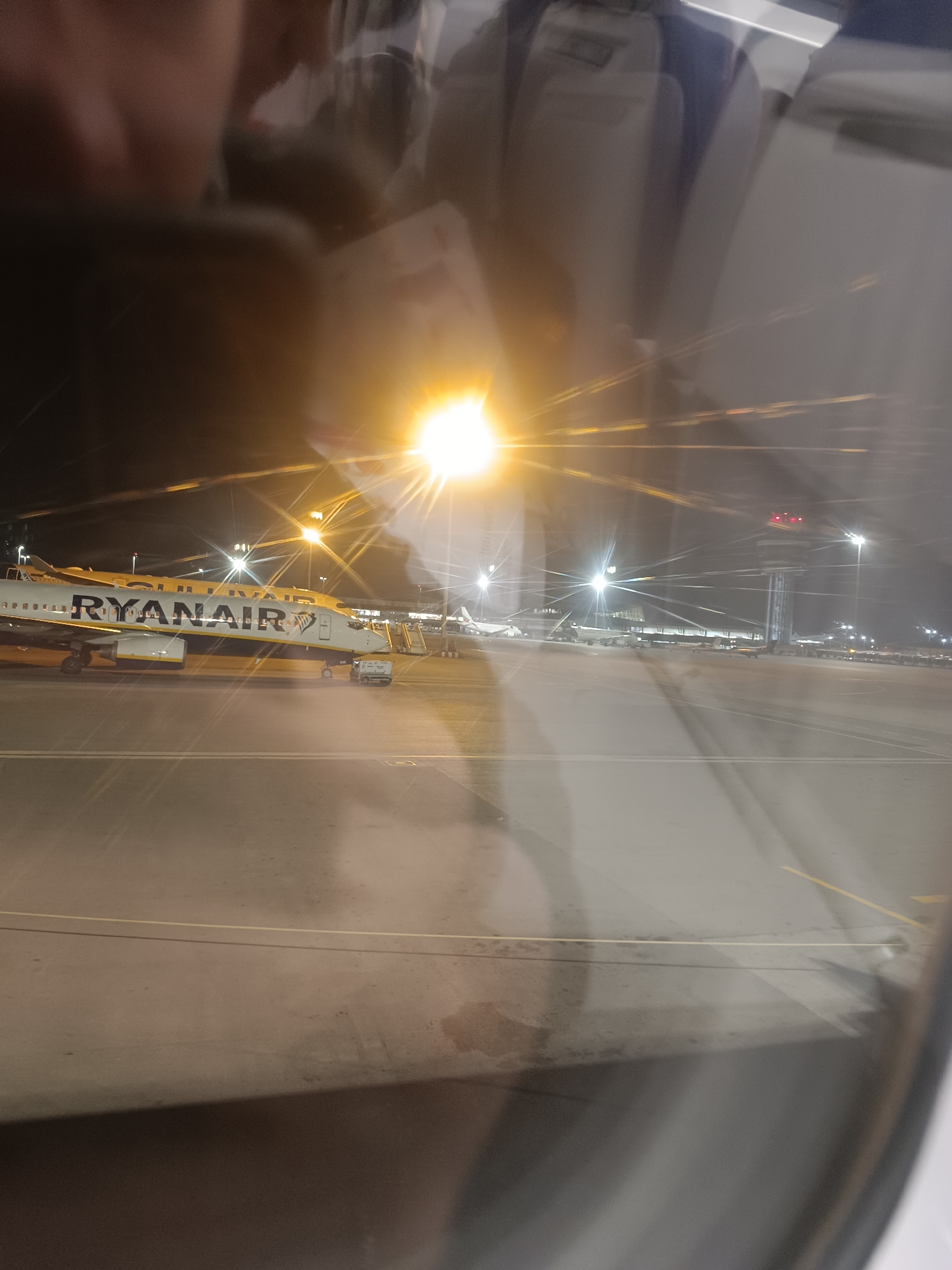 Nighttime airport scene with parked Ryanair aircraft photographed