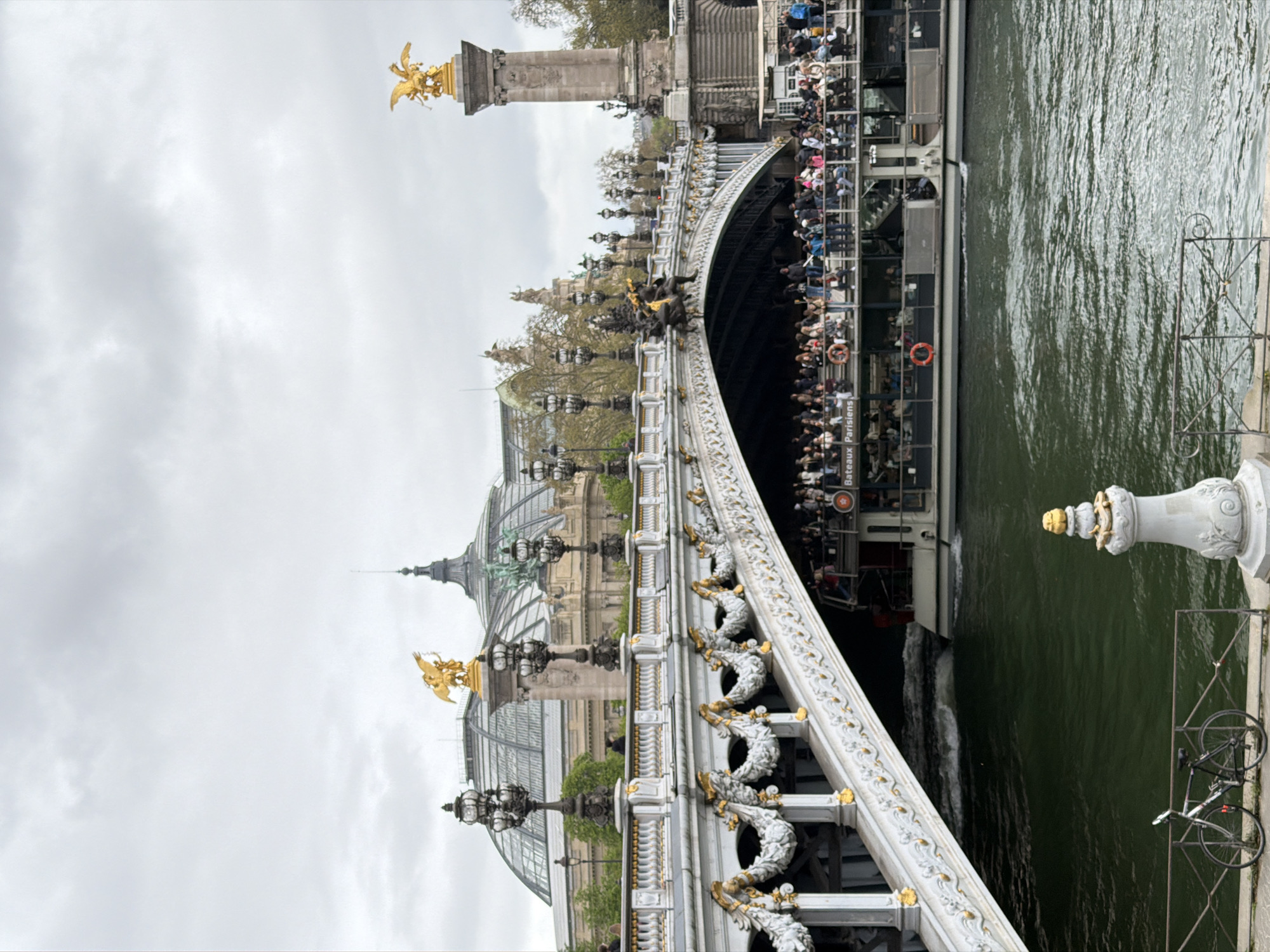 Tourist boat passes under ornate Pont Alexandre III in Paris
