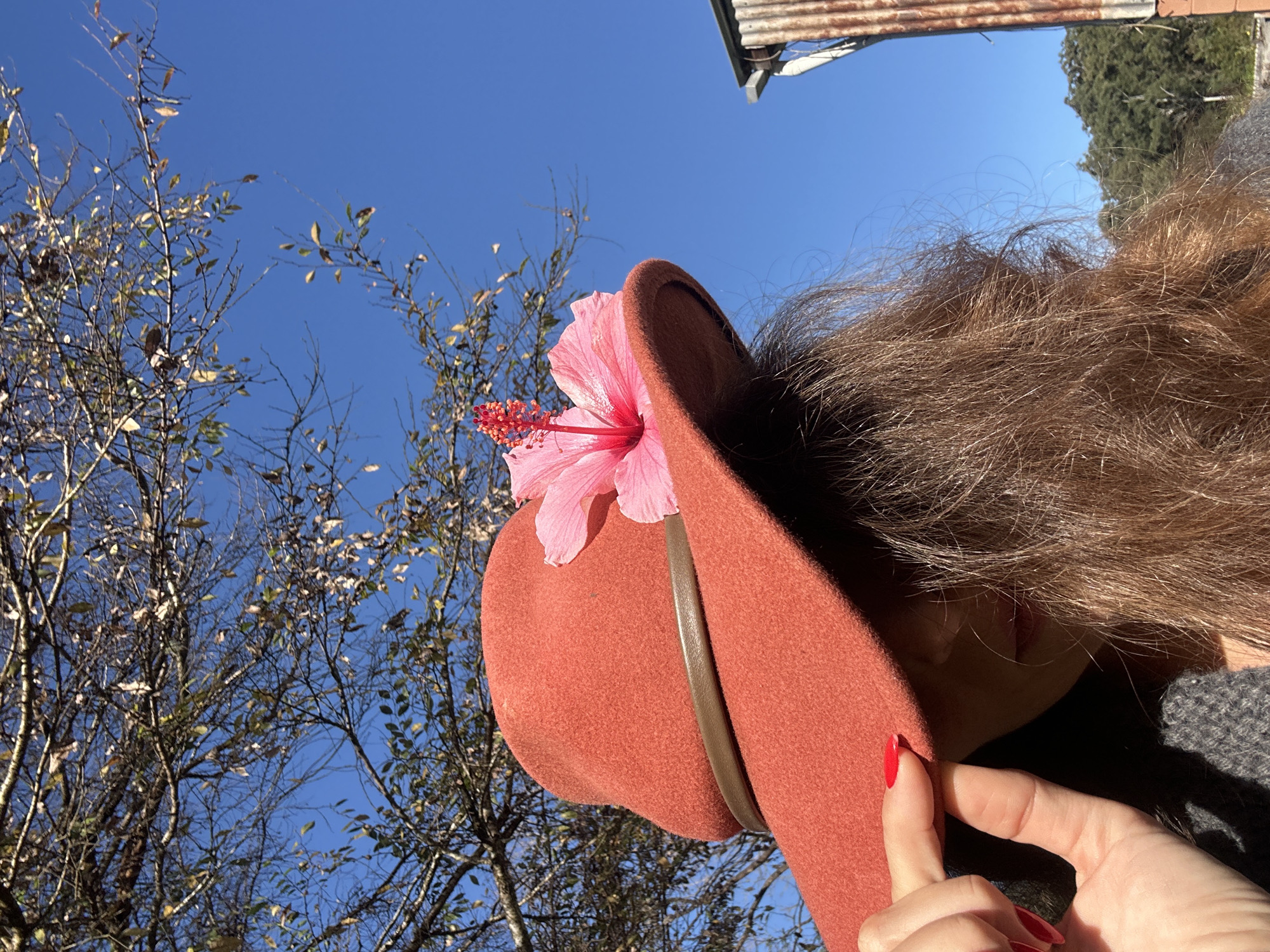 Felt hat with hibiscus flower, styled and shot outdoors in Thora