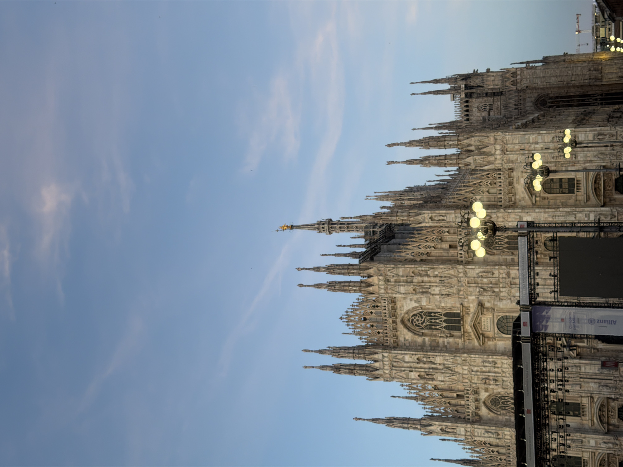 Pedestrians gather around Milan's Duomo during overcast afternoon