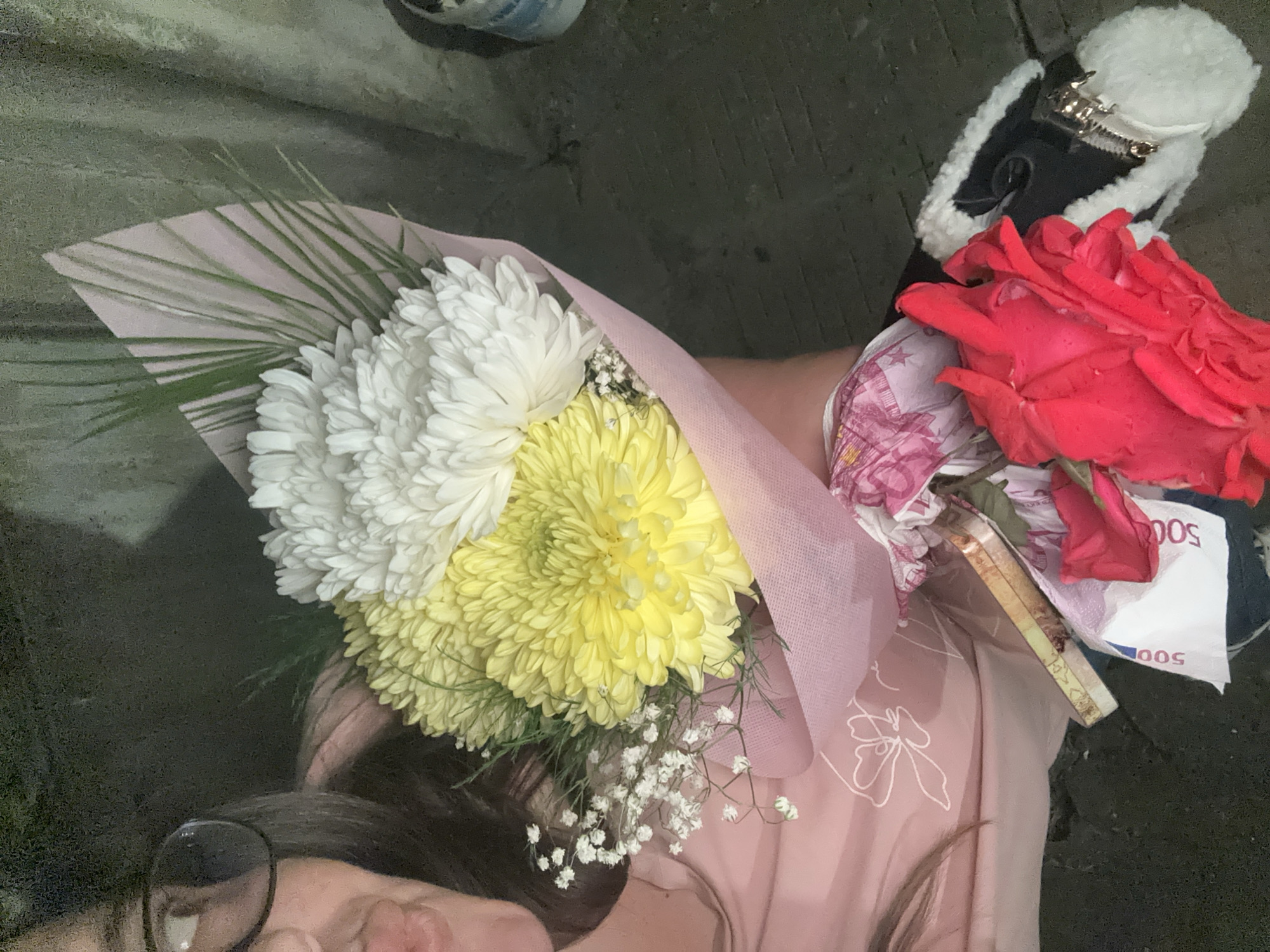 Person holds flower bouquets and money in Bulgarian village