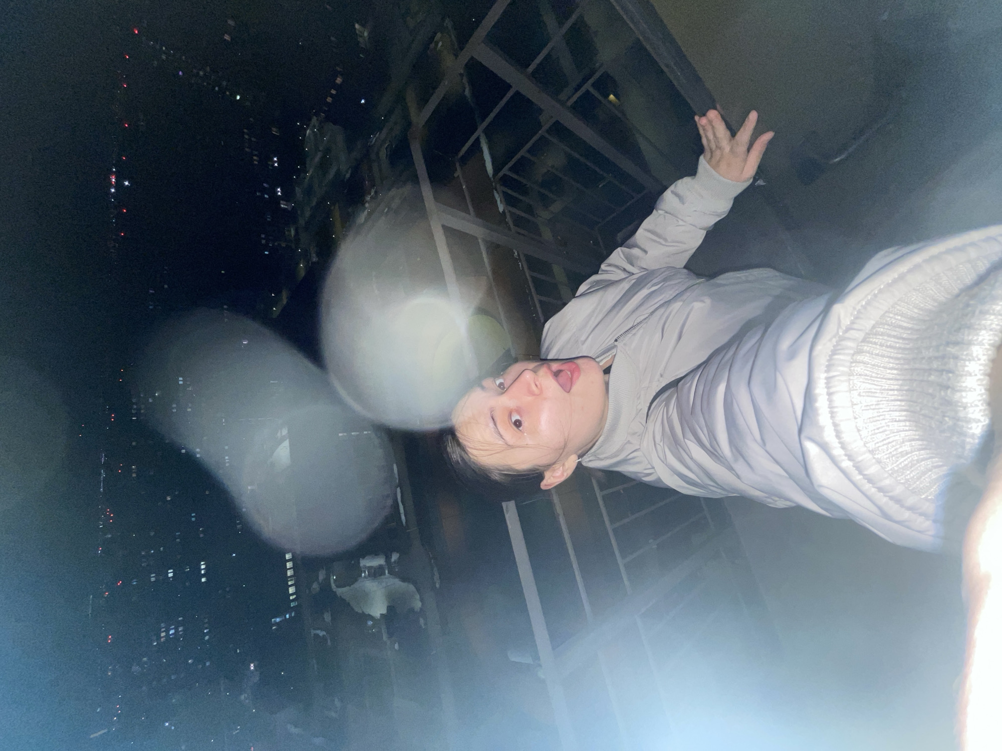 Person takes playful nighttime selfie on rooftop in Balashikha