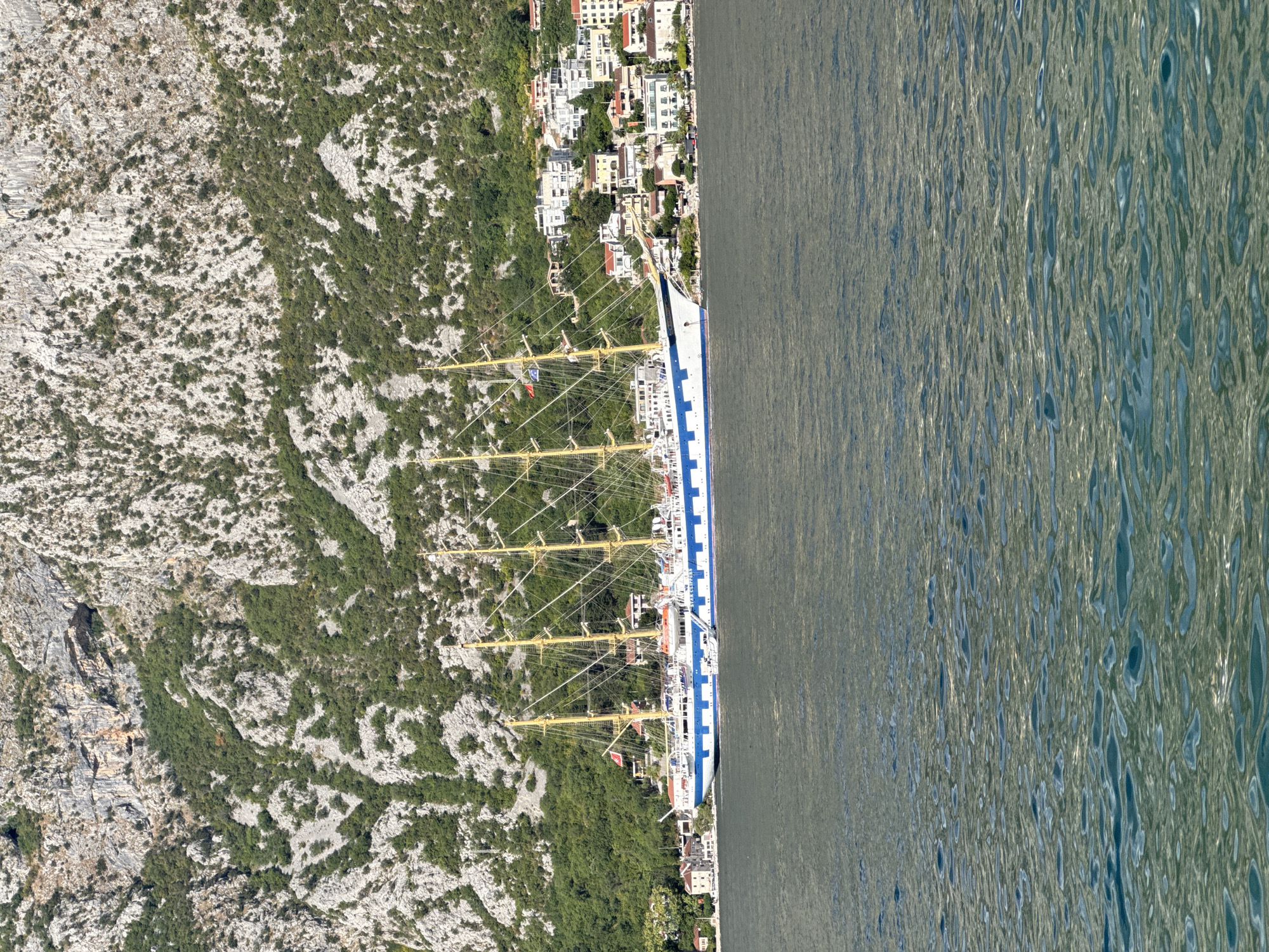 Tall ship anchored in Prčanj bay, locals lounging waterside