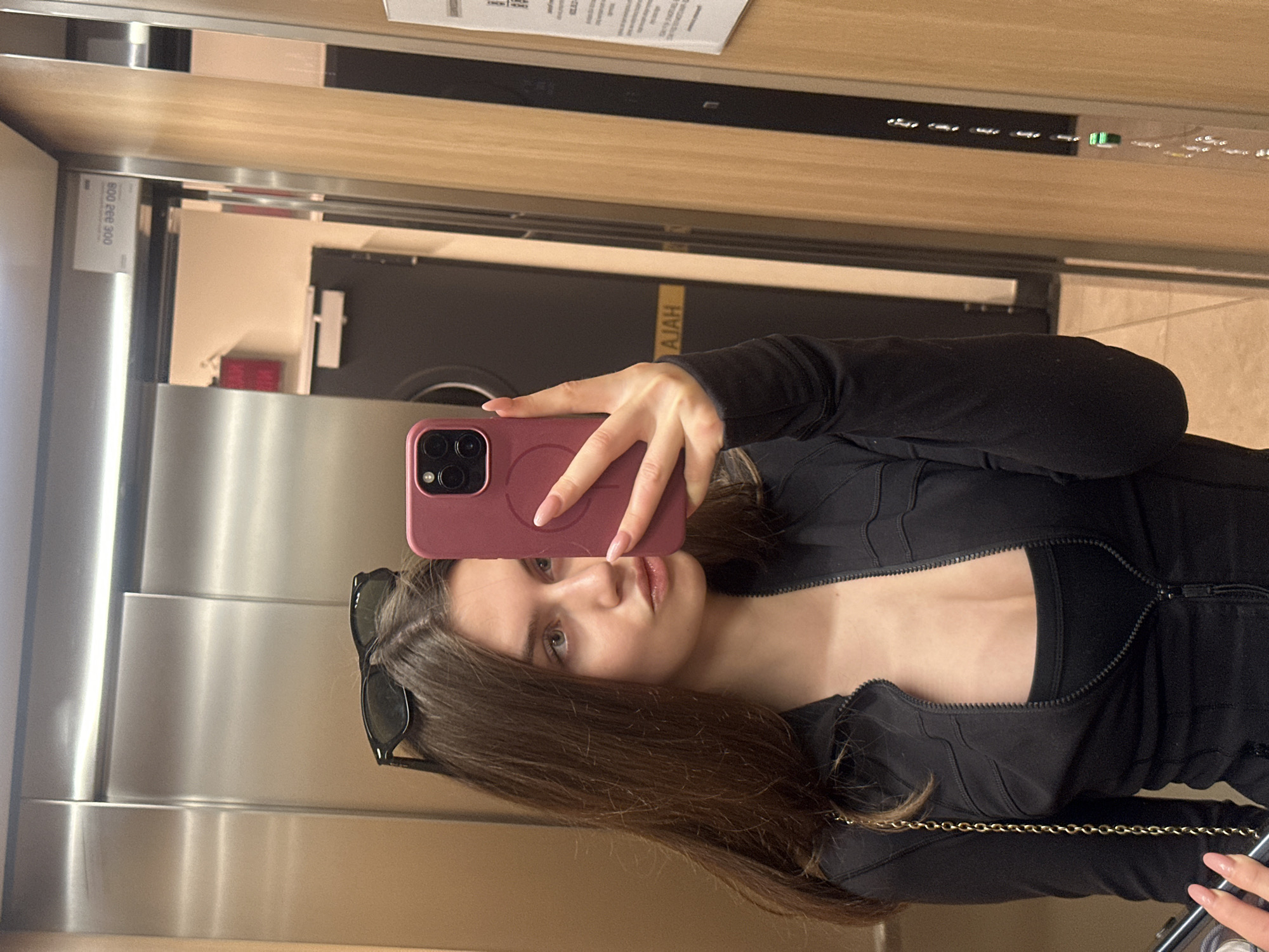Woman takes selfie in elevator with pink phone