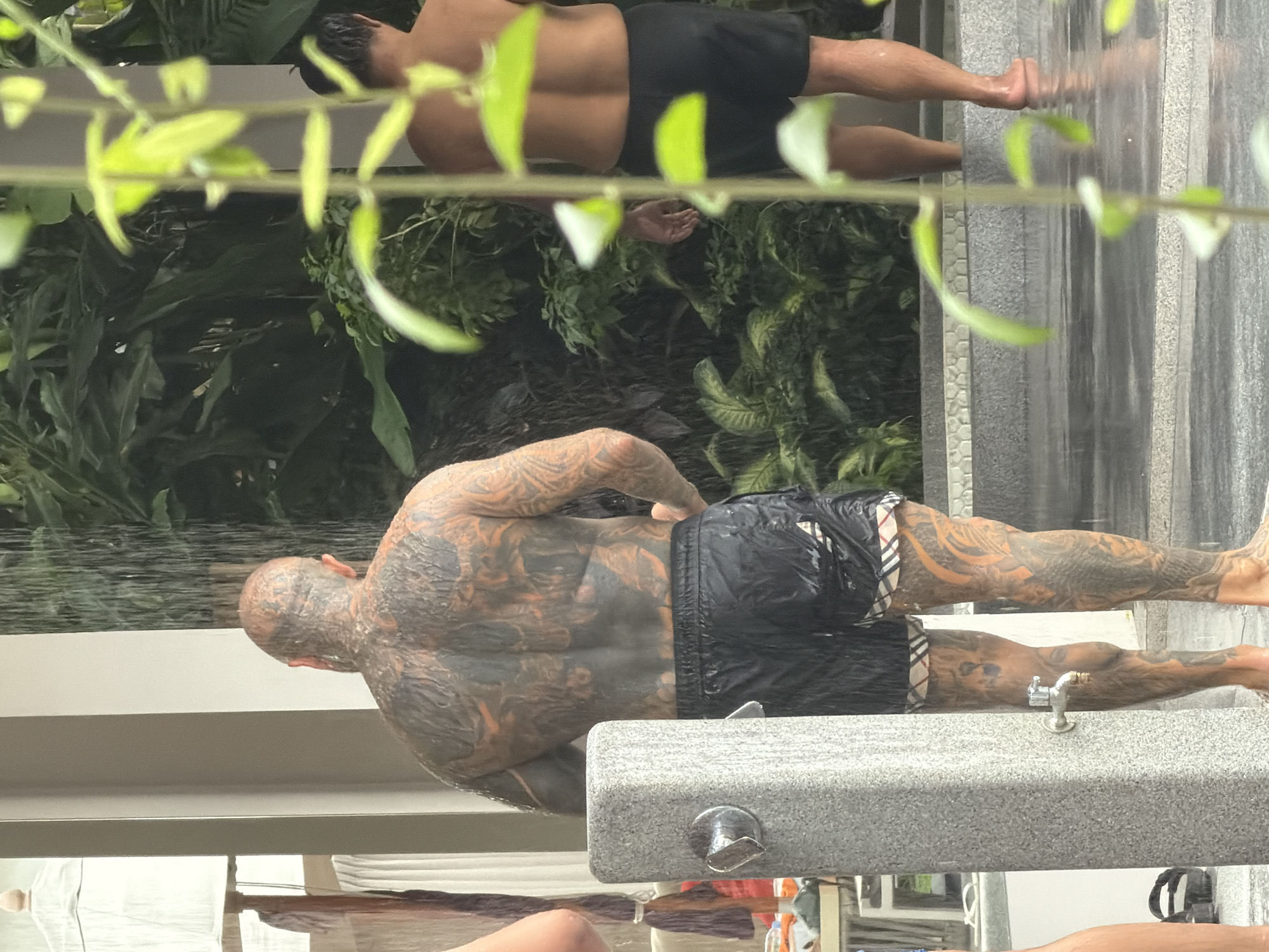 Fresh tattoo aftercare at an outdoor rinse station in Choeng Thale