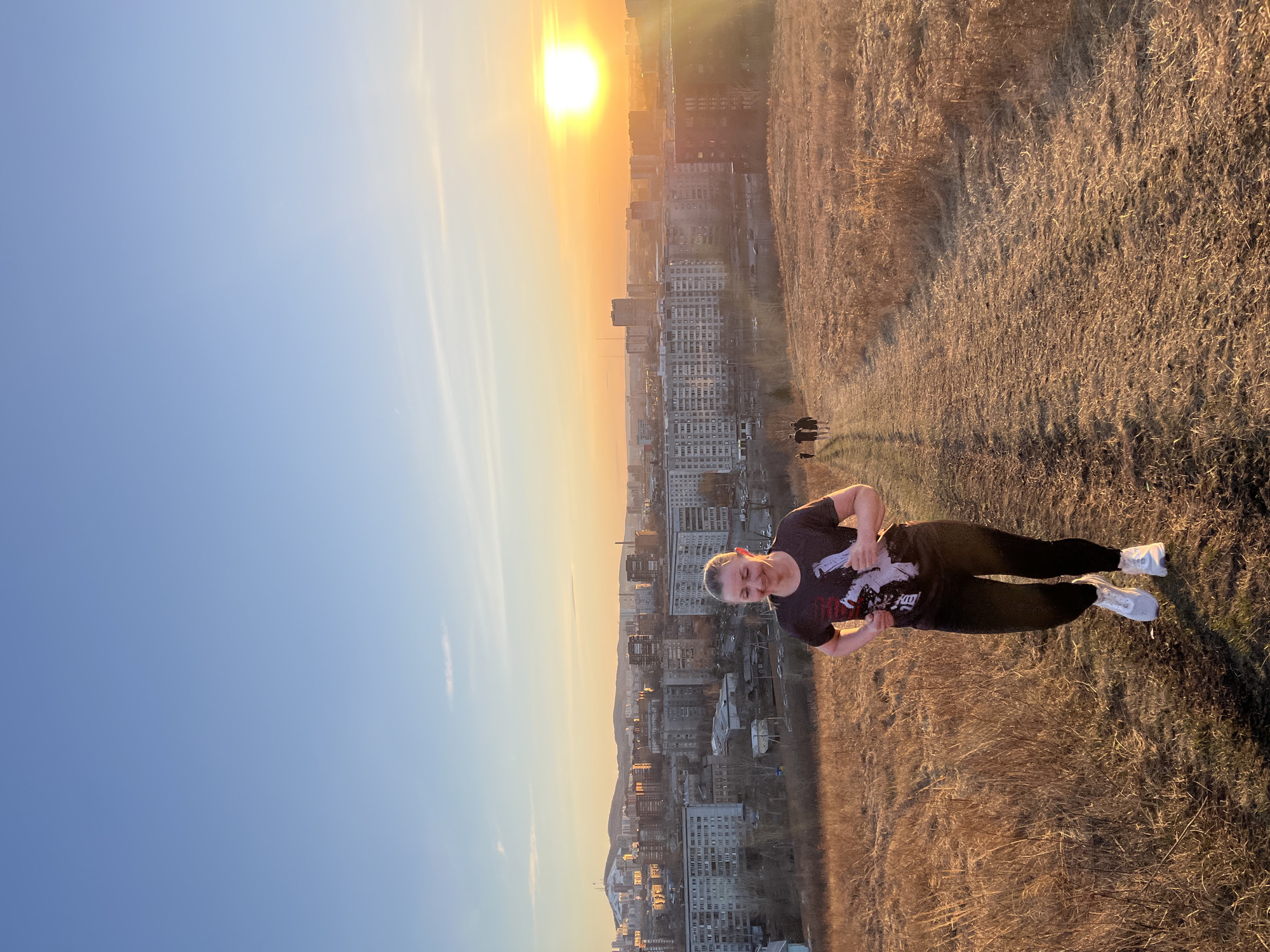 Woman photographs overlooking Krasnoyarsk during golden hour moment