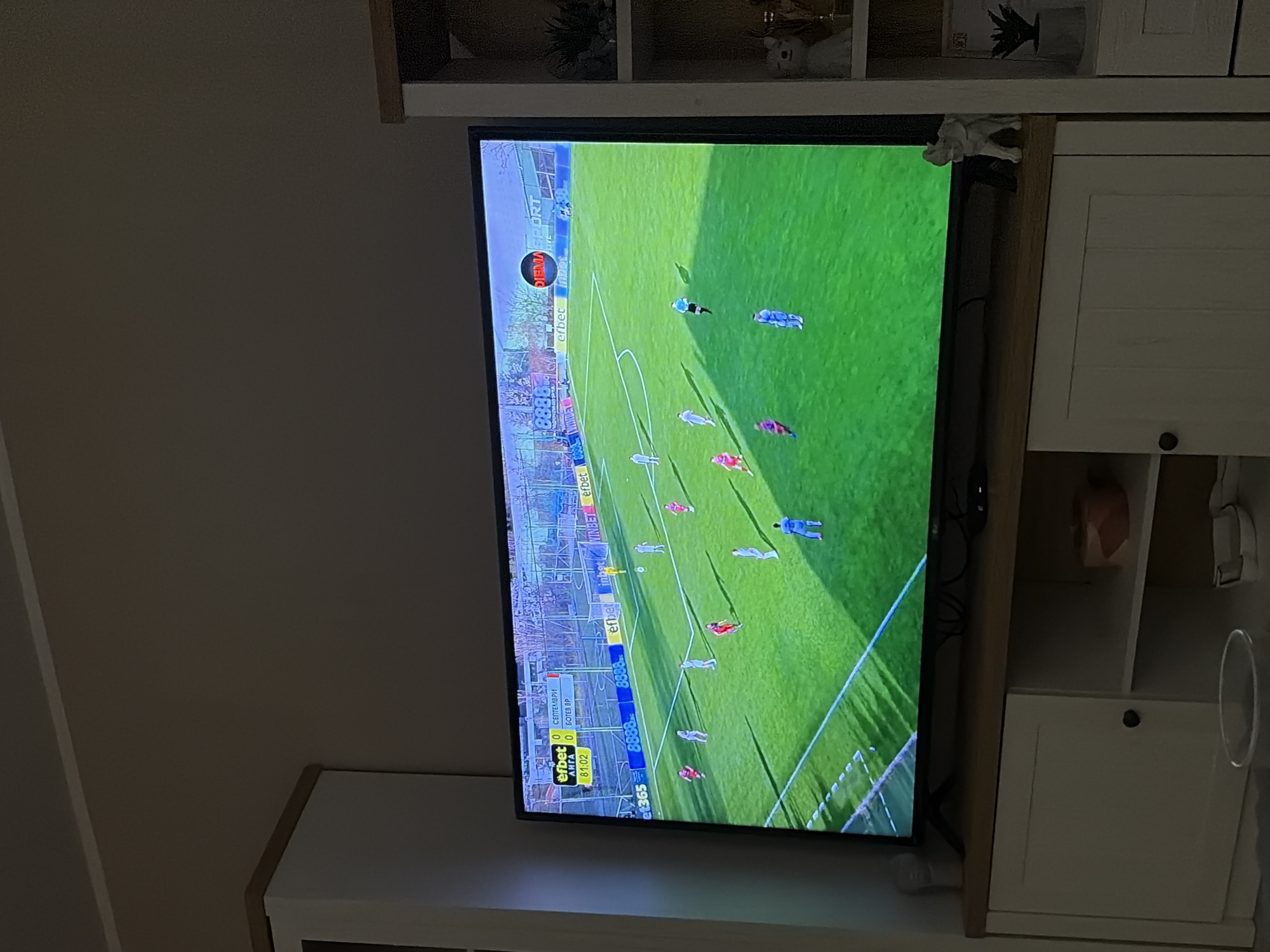Soccer game broadcast viewed on mounted television in Bulgaria