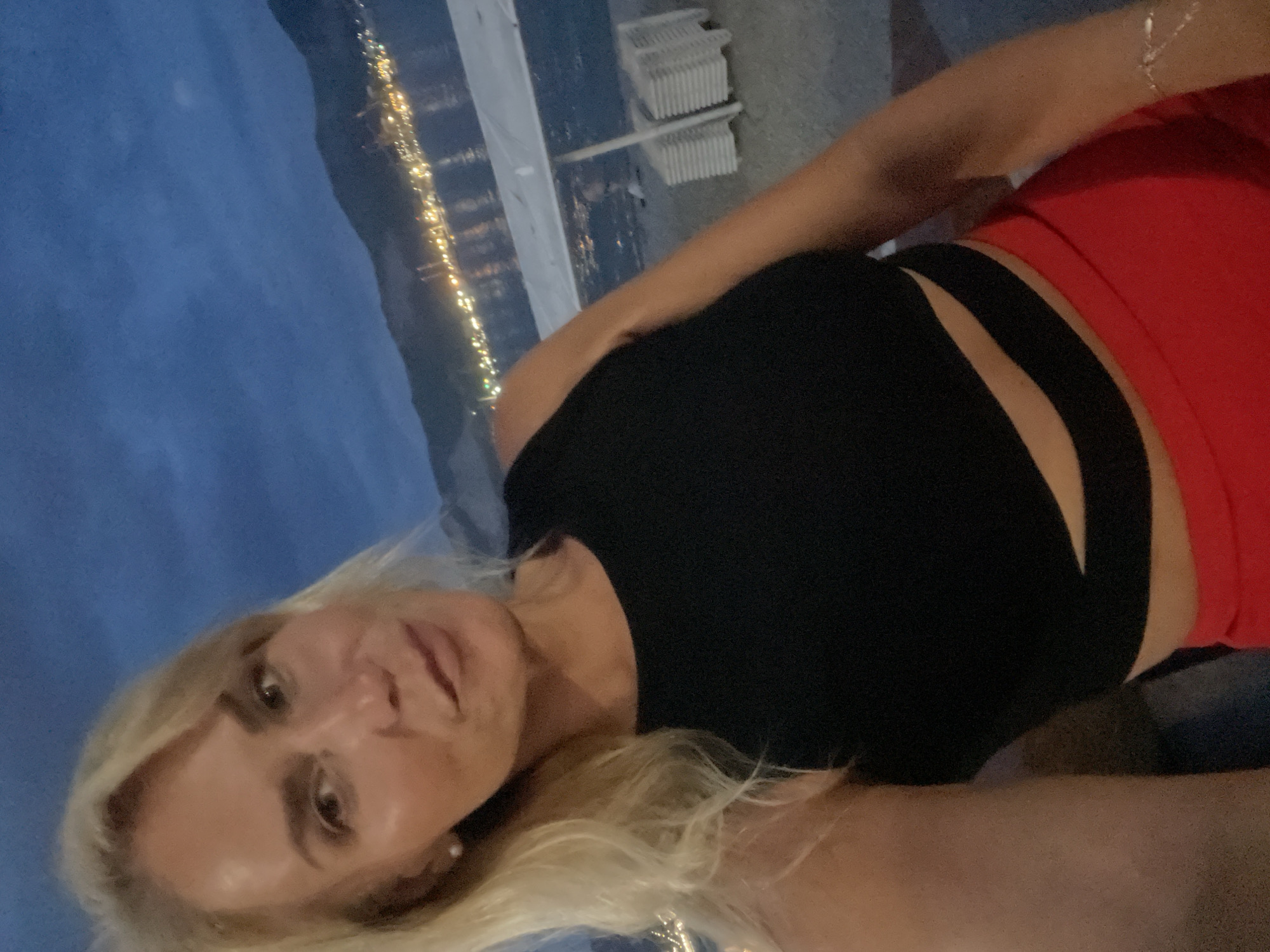 Nighttime beach selfie with glowing city skyline across the water