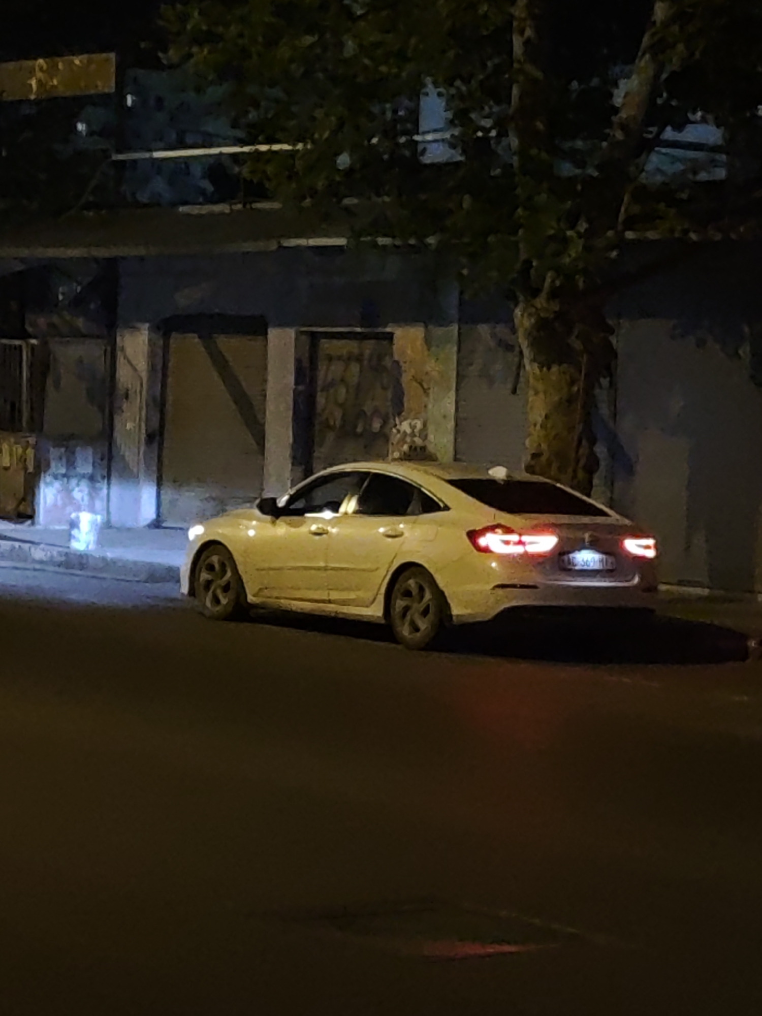 Sedan parked on a Tbilisi street at night, taillights glowing.
