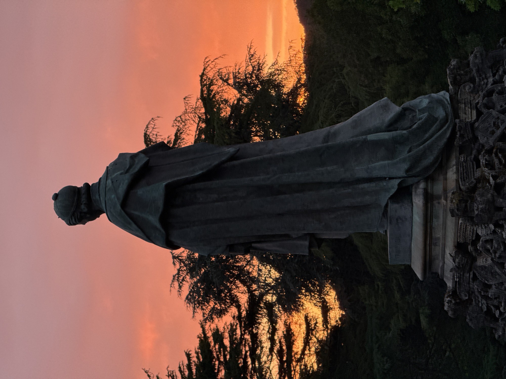 Sunset light over Alameda Park statues and trees, Santiago de Compostela