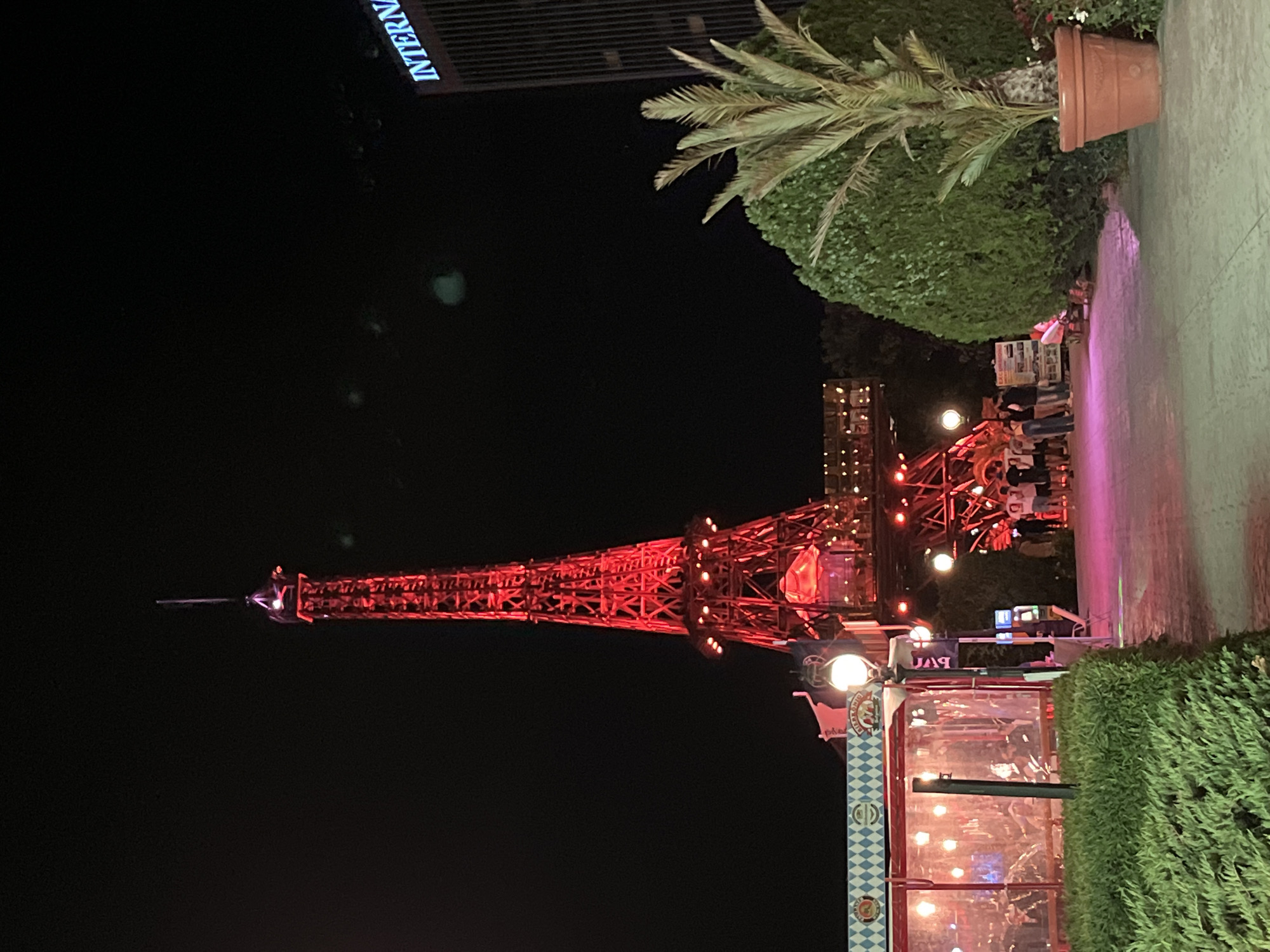 Varna's lit-up amusement strip at night: Eiffel replica, Ferris wheel, taxi.