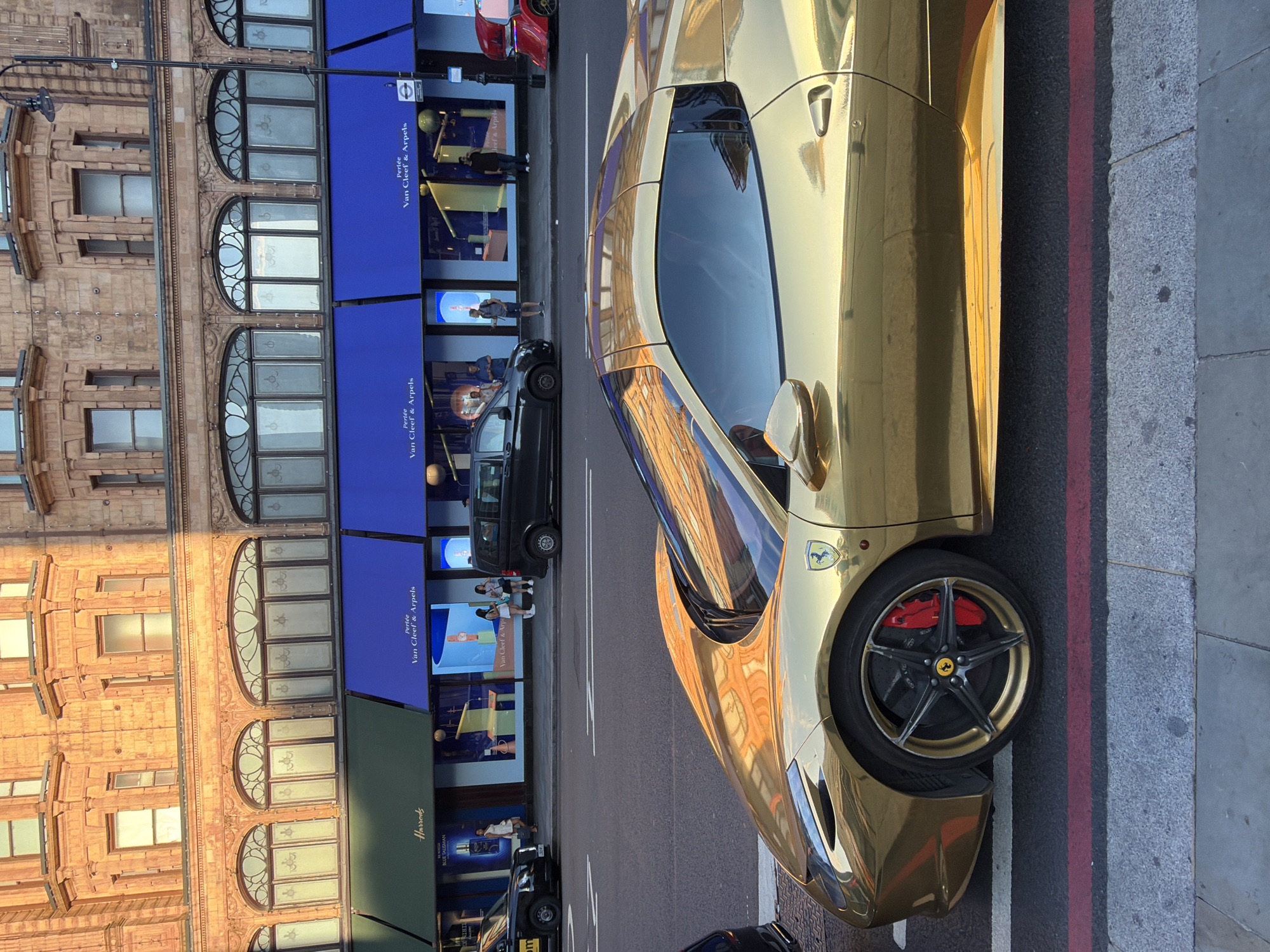 Gold Ferrari and Bentley draw attention on a London luxury street