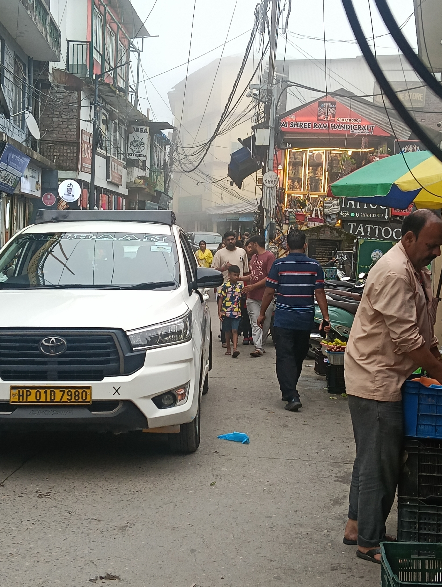 Foggy morning on a busy narrow street in Bhagsu, India