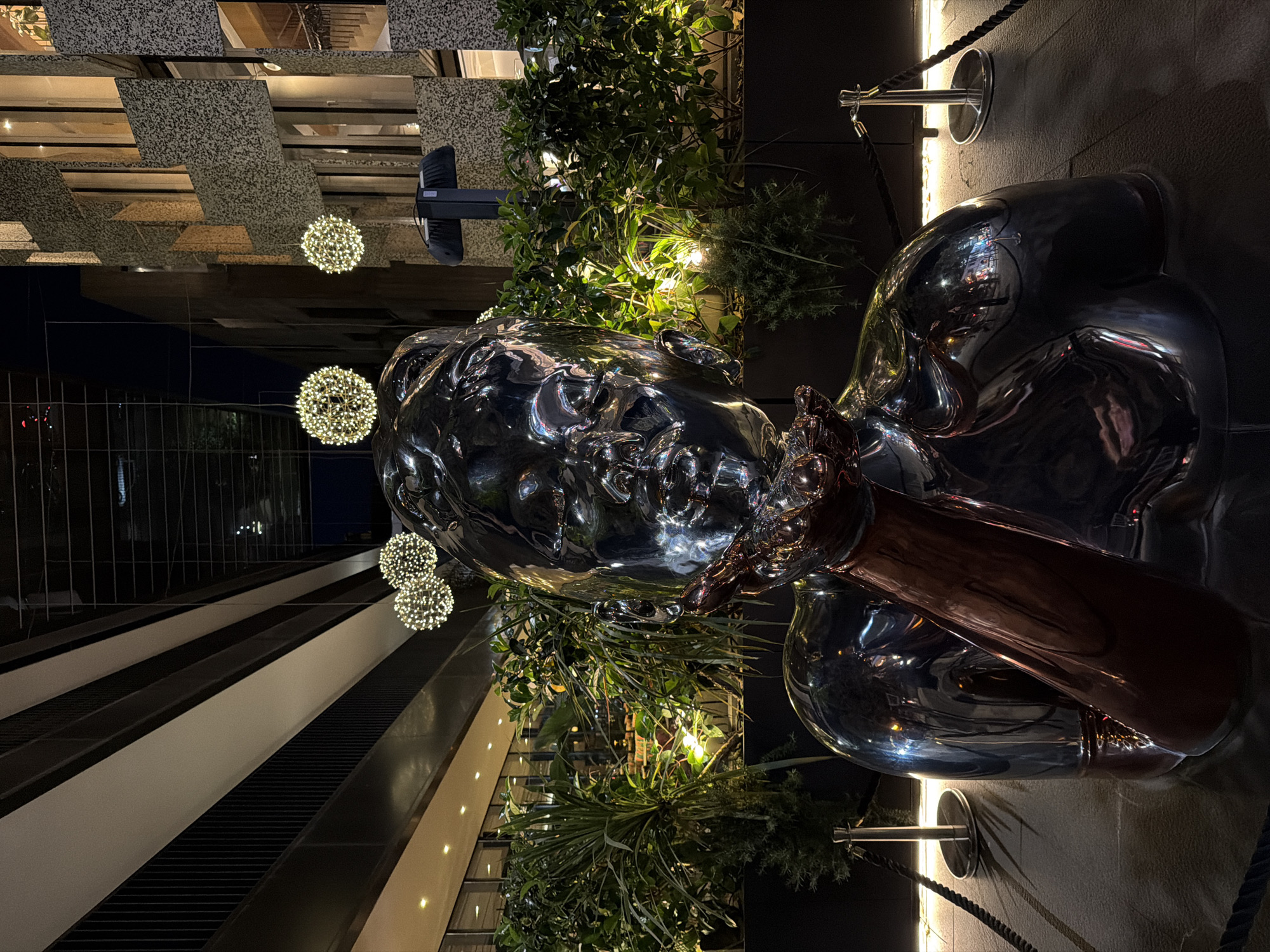 Illuminated metal sculpture observed in nighttime Tirana setting