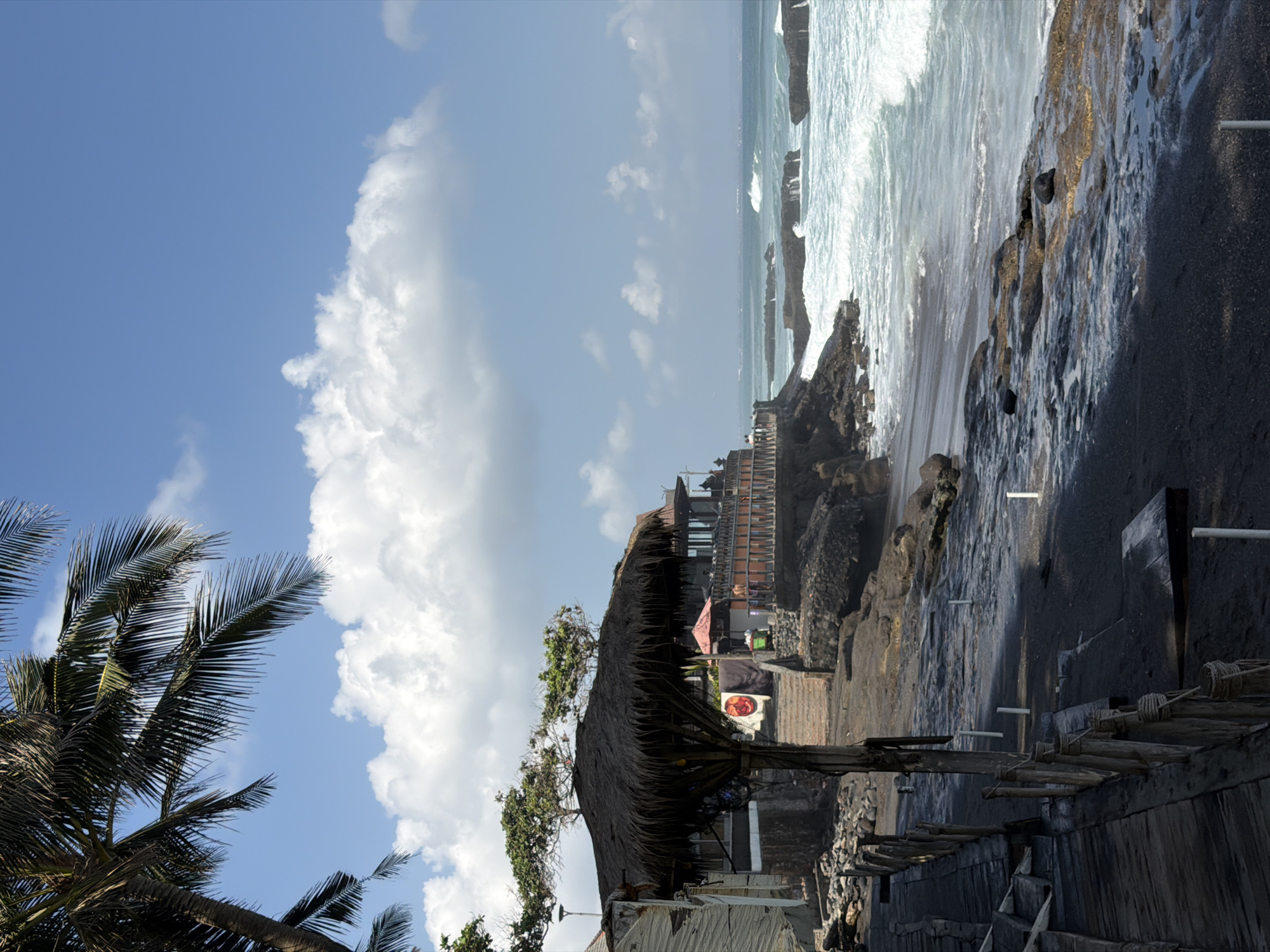 Rough surf and stormy skies hit North Kuta's black sand shore