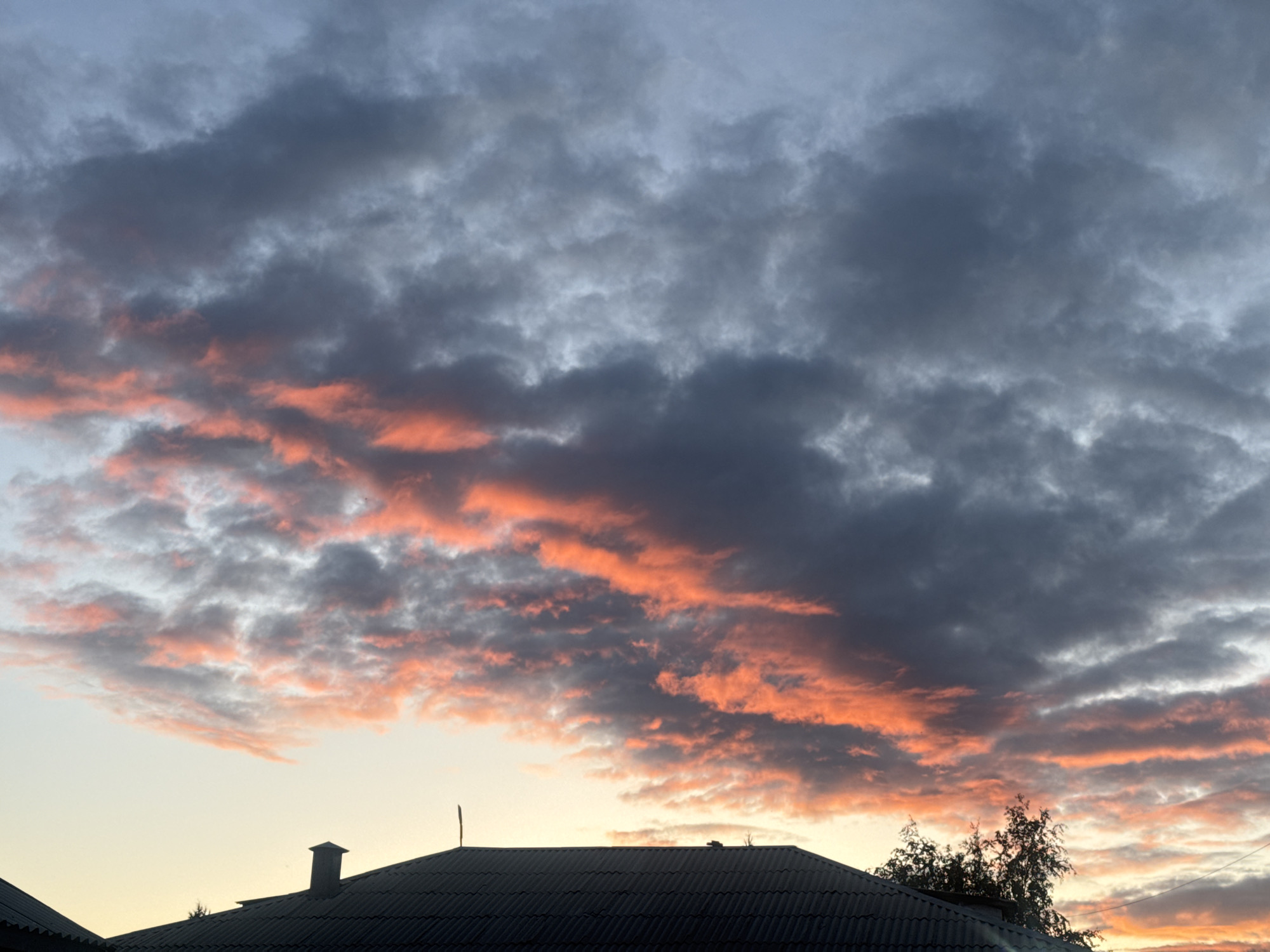 Bold orange and grey sunset over residential rooftops