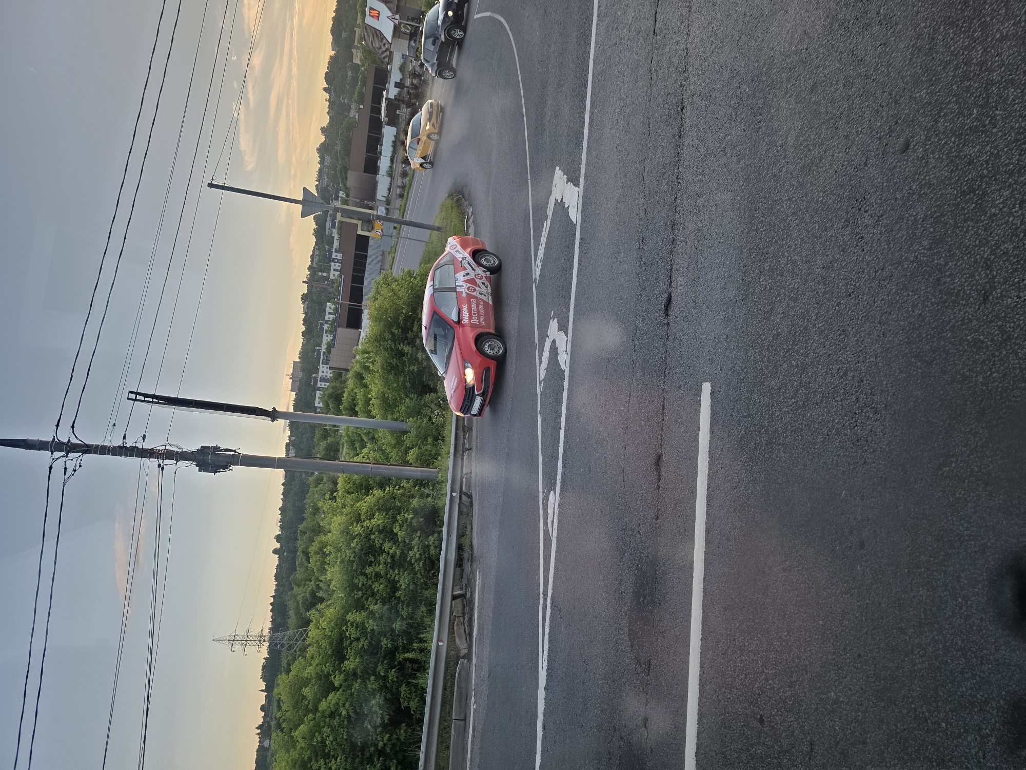 Dusk drive past a roadside McDonald's on wet urban streets